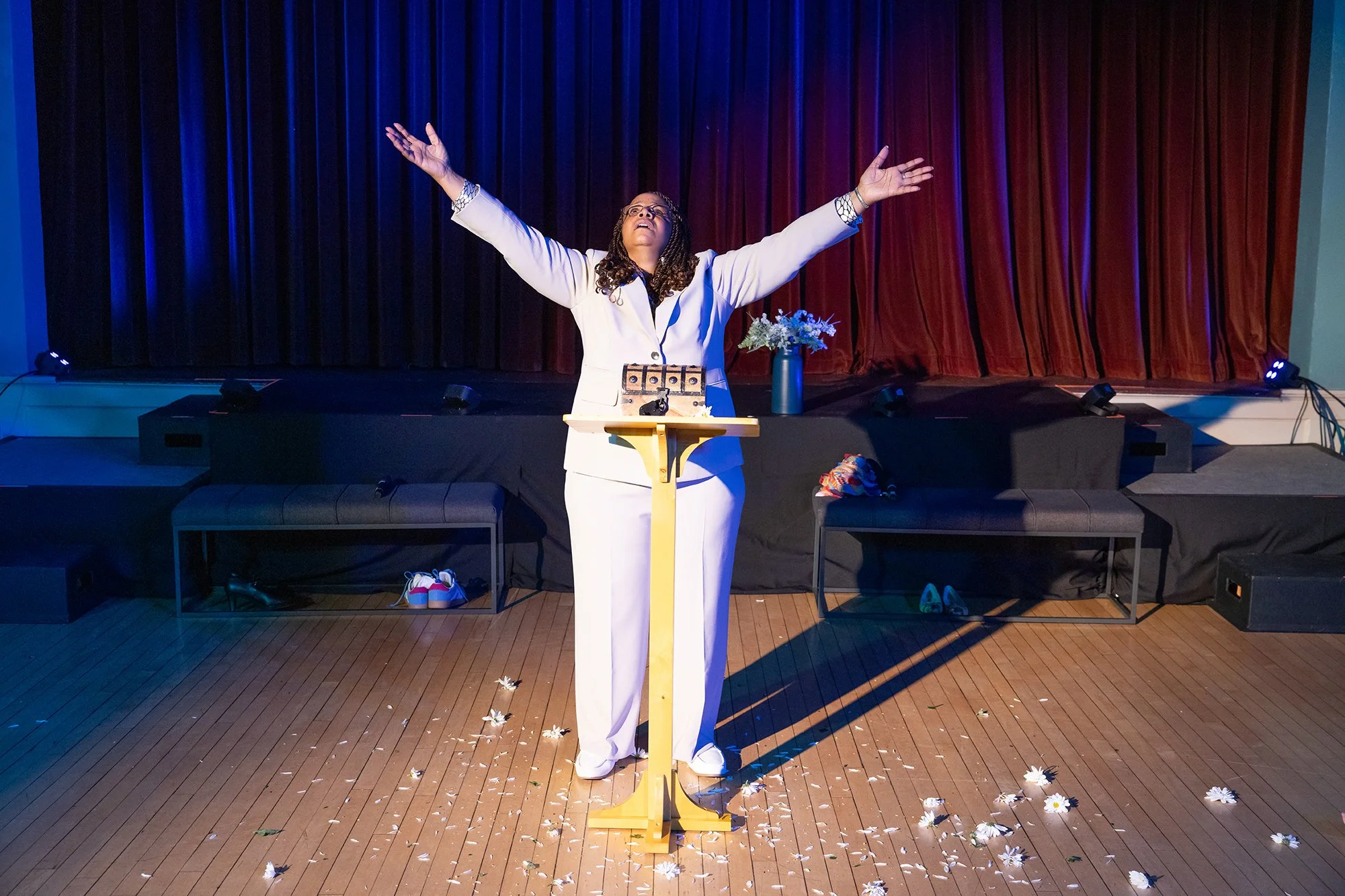 woman behind podium with arms raised in the air