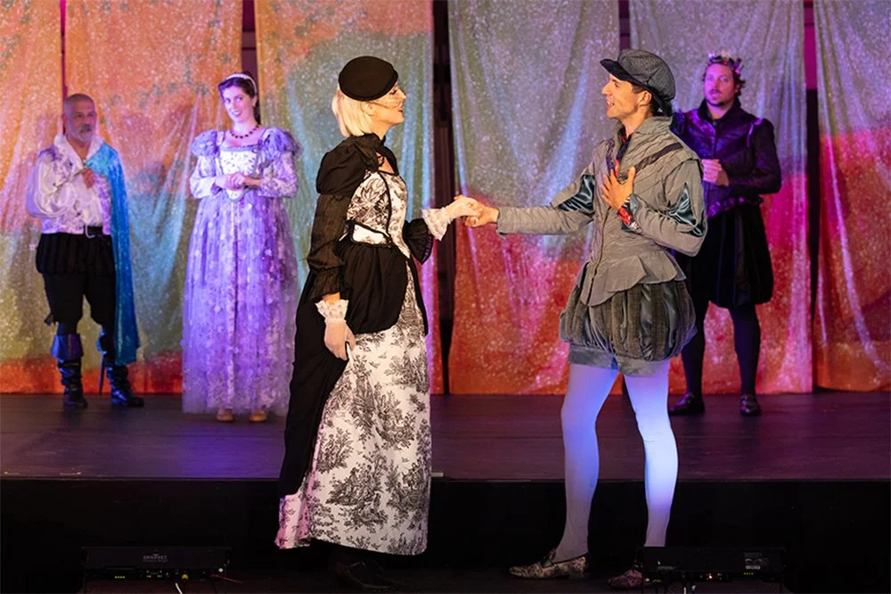 woman and man on stage holding hands and looking at each other