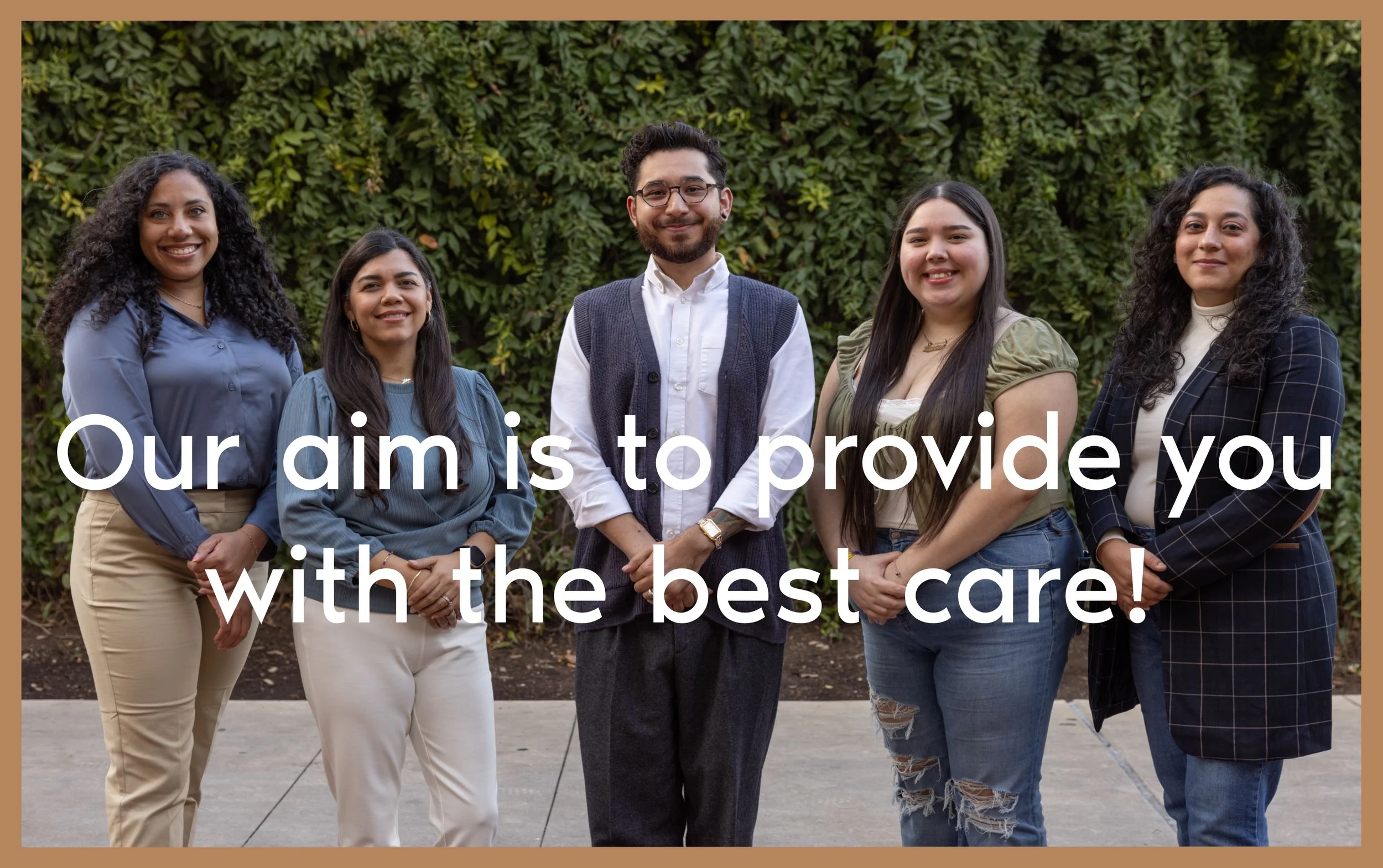 A group of five diverse people smiling and standing in front of a leafy green background. They are dressed in smart casual attire. Text on the image reads, "Our aim is to provide you with the best care!"