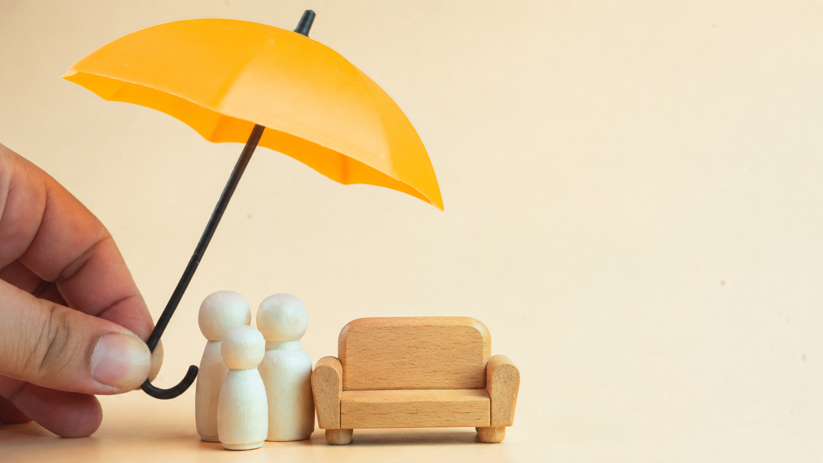 A tiny Umbrella overhanging a tiny family and a little wooden therapy couch.