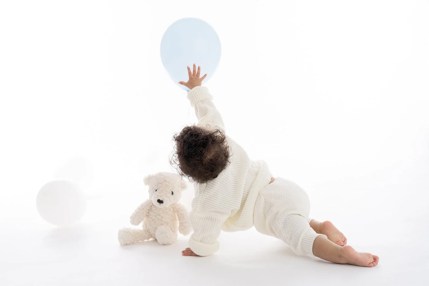One year old baby boy sitting on a white backdrop during a simple one year baby photography session in Columbus Ohio