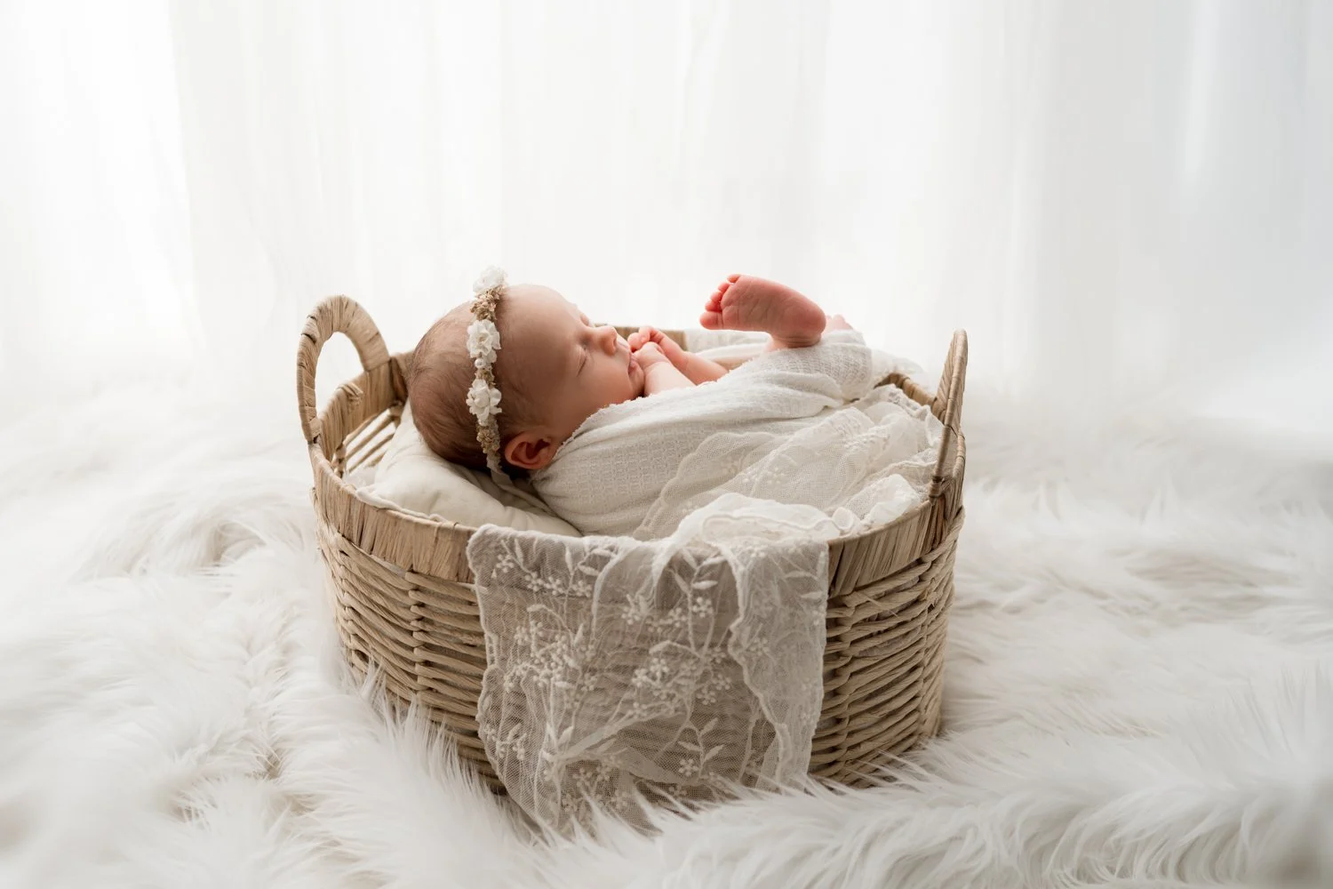 Baby girl in white in basket for columbus ohio newborn photography session