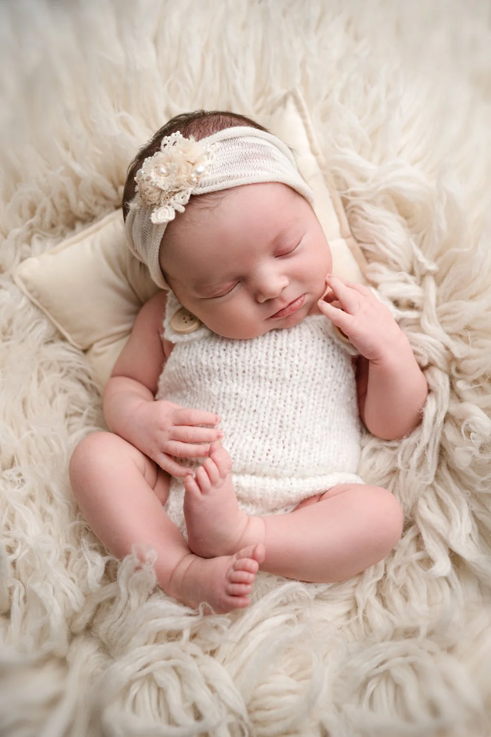 photo of baby girl in white for newborn photography session at Dublin ohio baby studio
