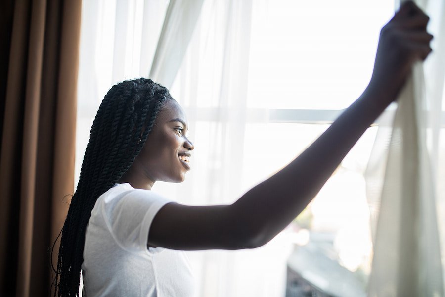 Black woman looking out the window representing feeling hopeful after seeking Adult ADHD Treatment in San Francisco, CA