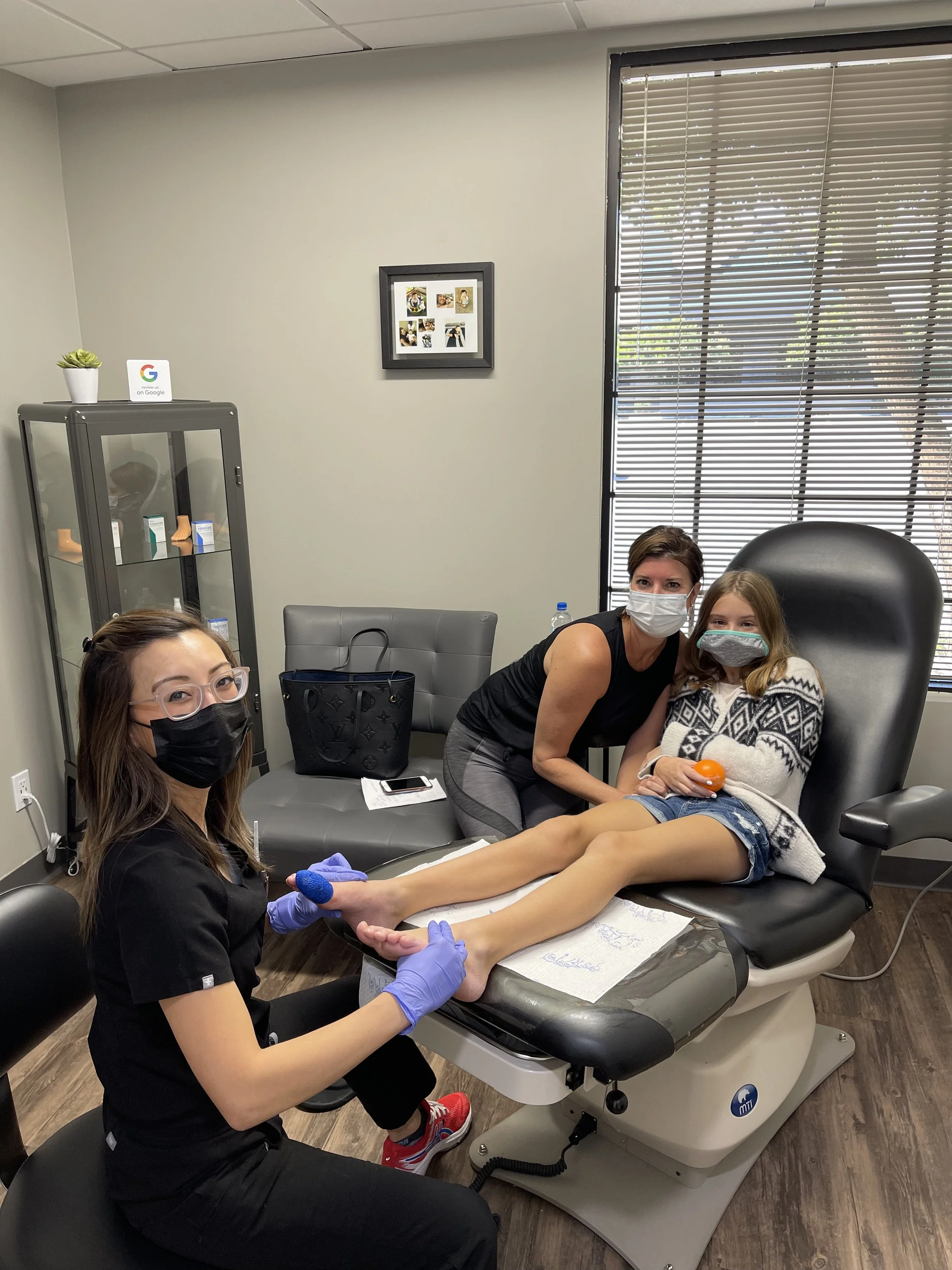 Dr. Stocks treating a pediatric podiatry patient accompanied by her mother