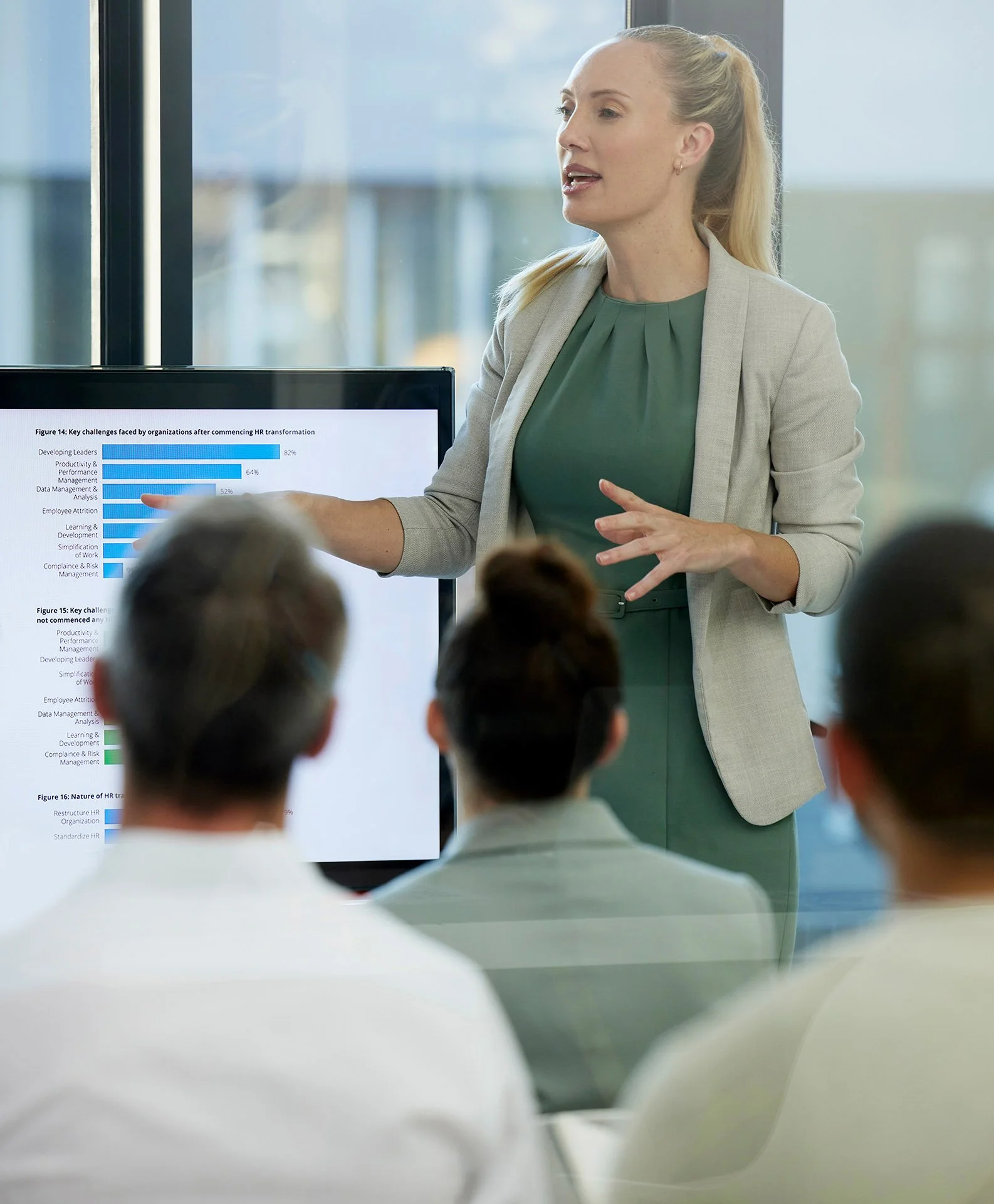 Professional woman shares her expertise leading team of participants in presentation in office
