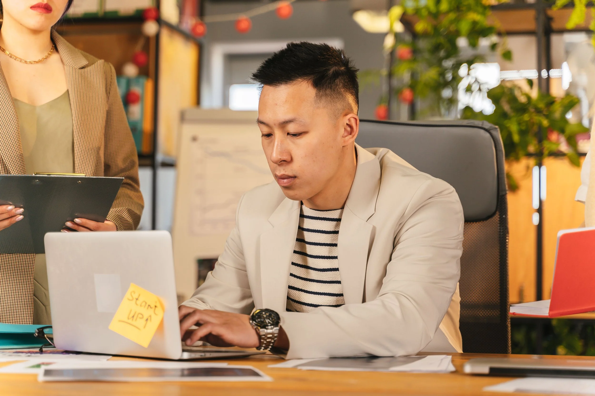 Person completing a task while a supportive colleague observes nearby