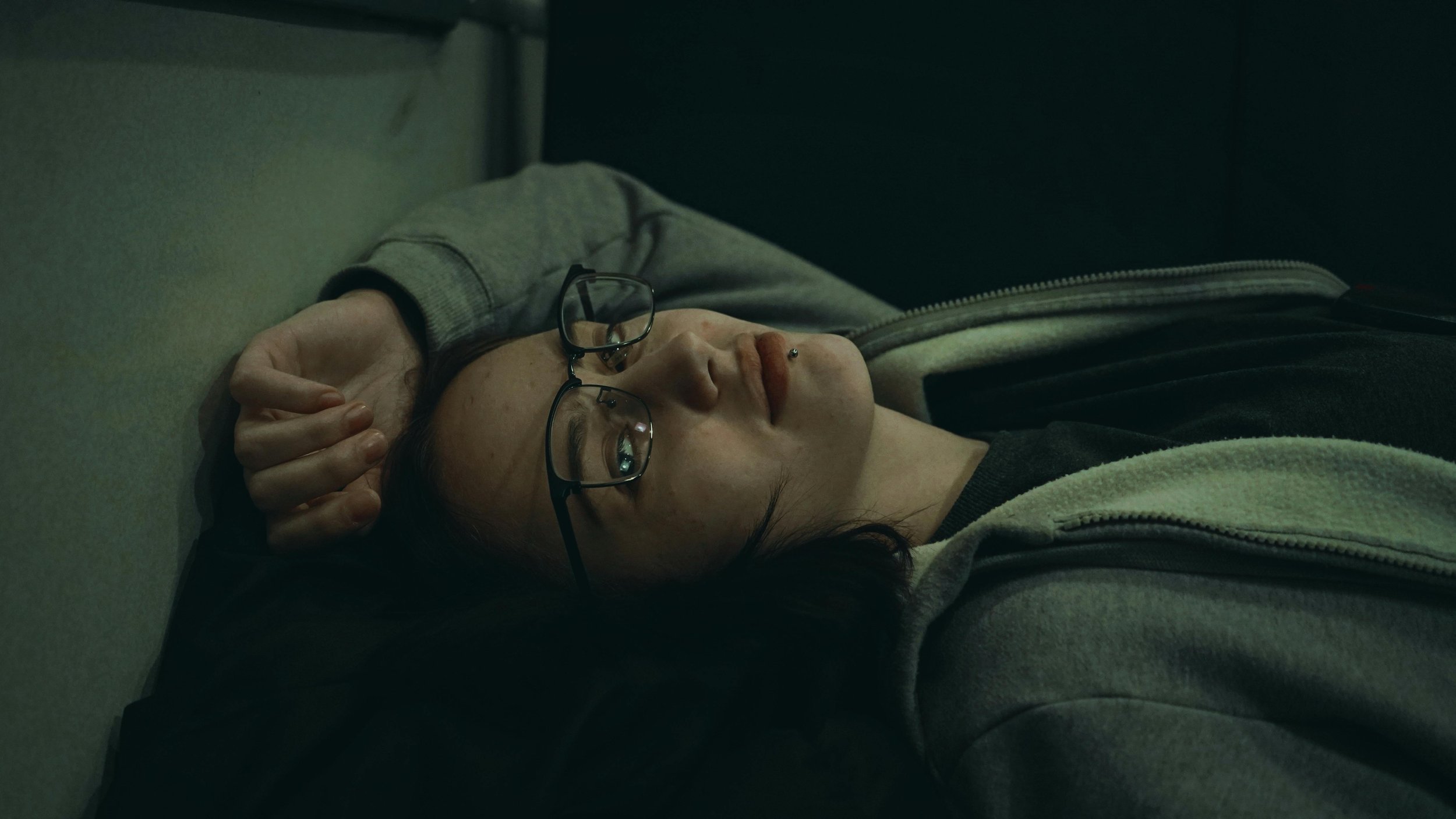 Person lying awake in bed feeling exhausted but unable to fully relax or rest