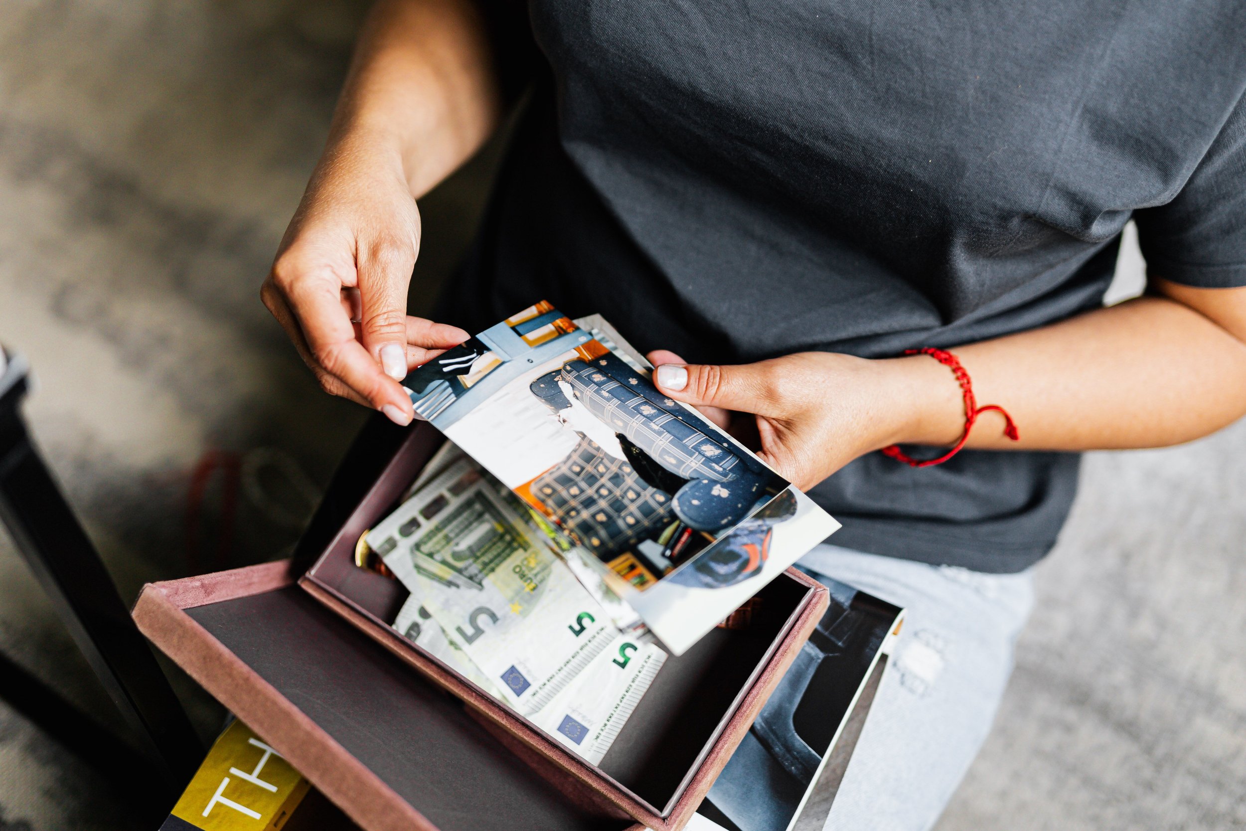 Adult thoughtfully sorting meaningful belongings and family keepsakes at home