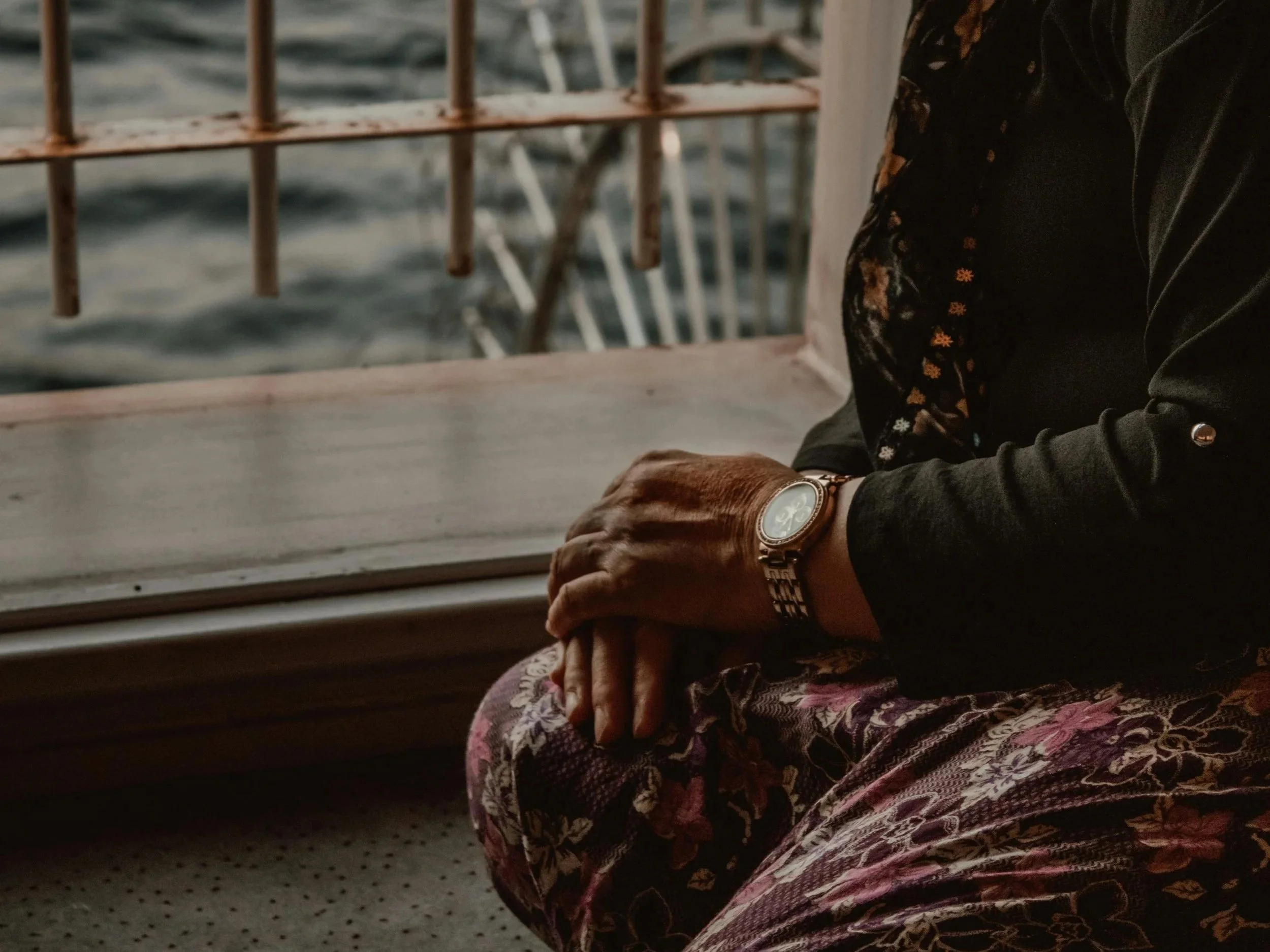 Person sitting by a window in quiet reflection, representing the nonlinear experience of grief and loss.
