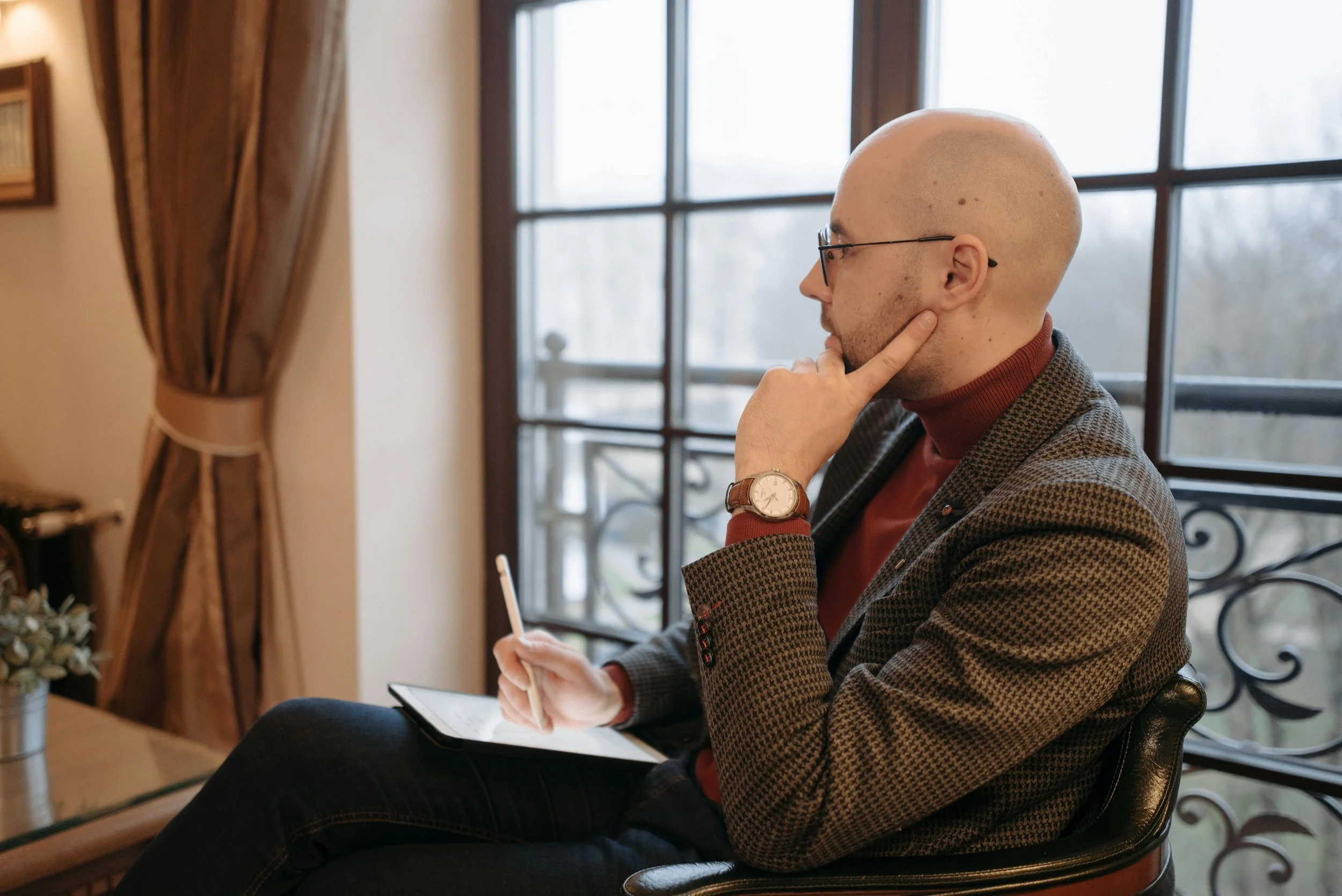 Person sitting thoughtfully in a counselling session with soft natural light