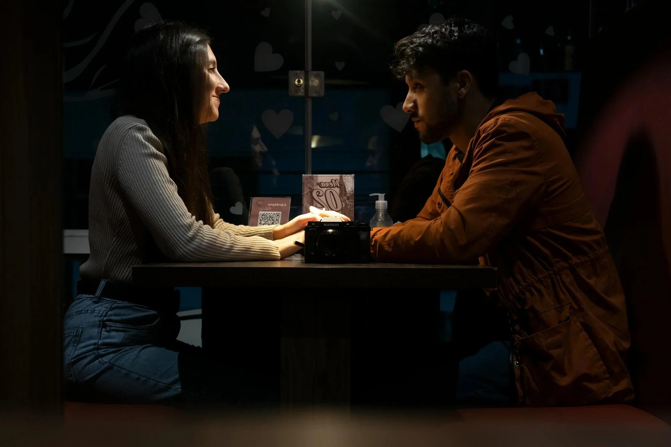 Couple at a café, one partner appearing tense while the other offers gentle support — symbolizing how social anxiety affects relationships