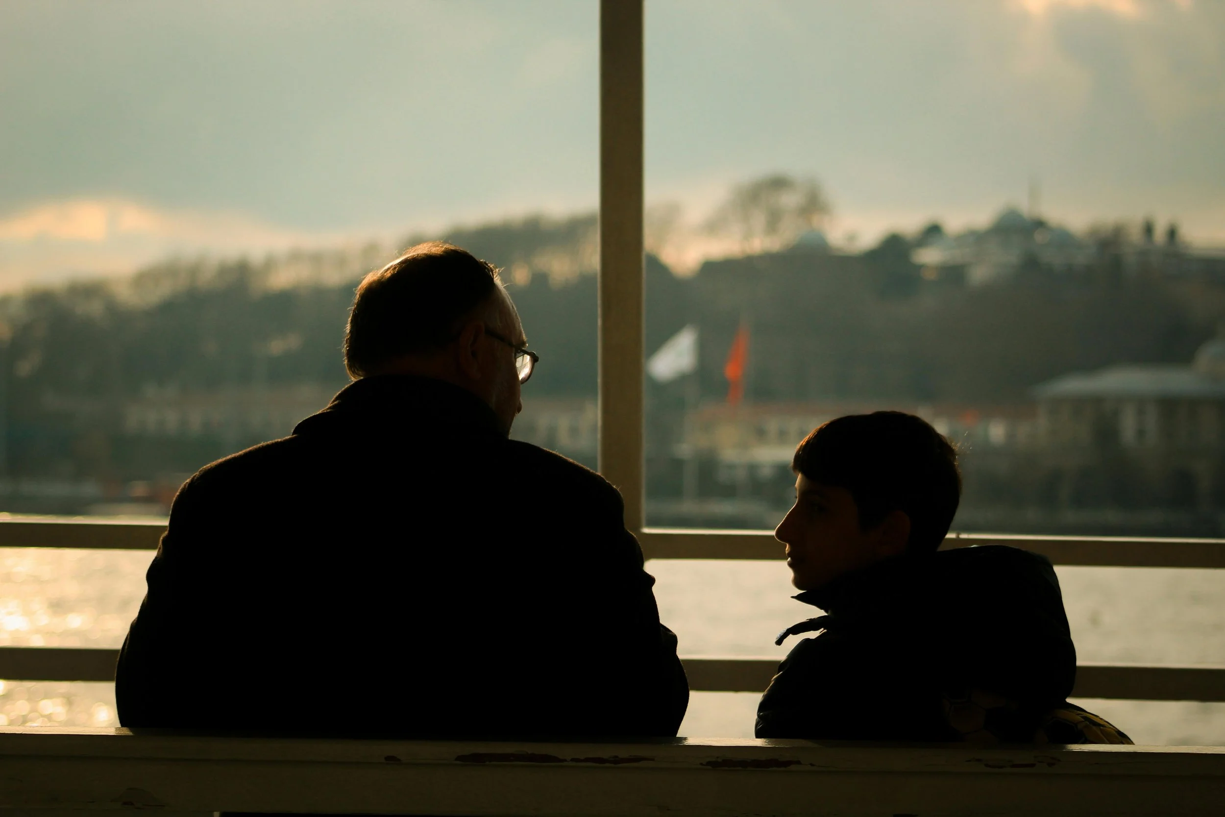 Parent sitting with child at eye level after an emotional moment, symbolizing connection and understanding behaviour as communication.