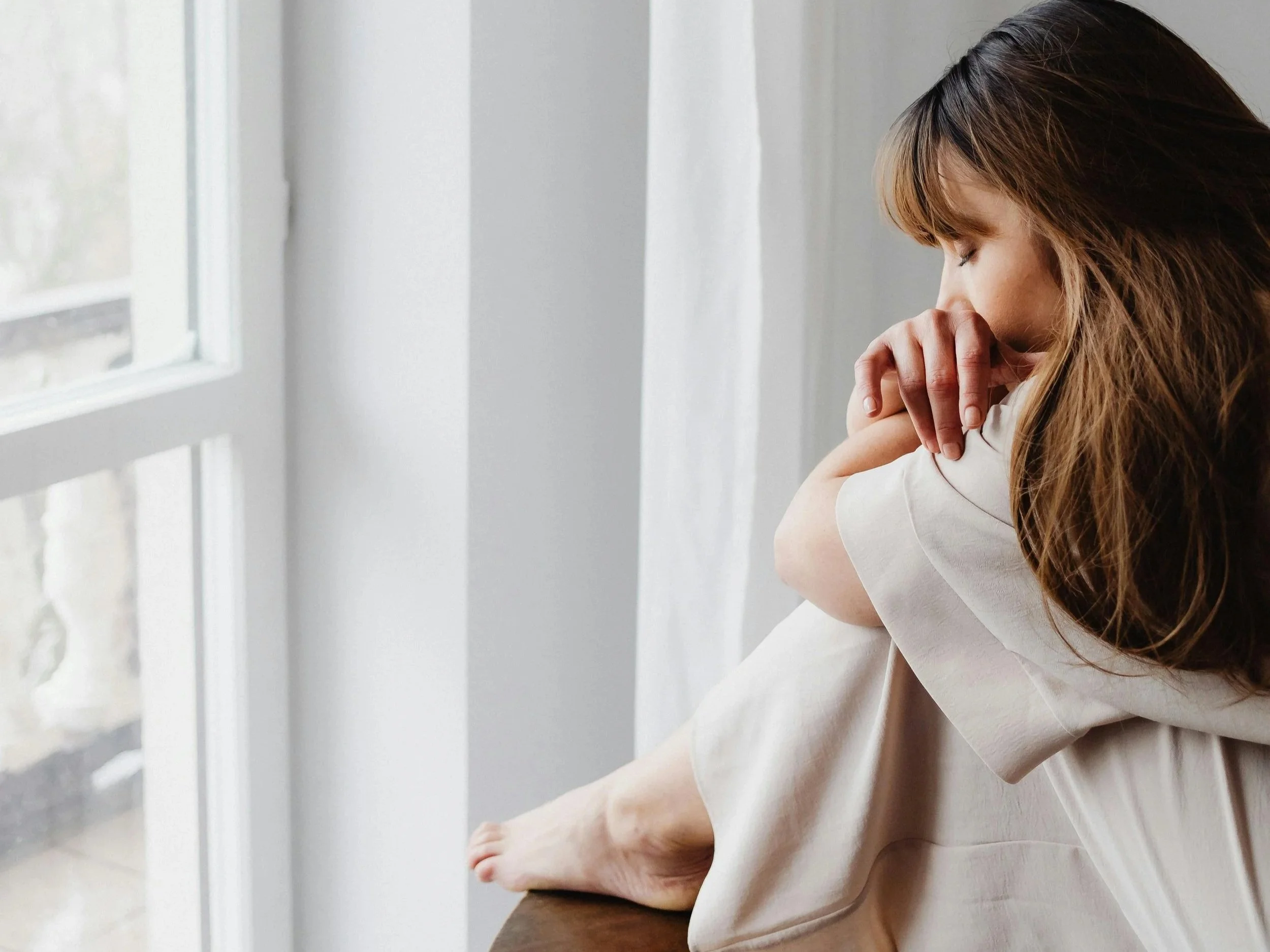 Person quietly reflecting during an online therapy session where emotional processing happens without words
