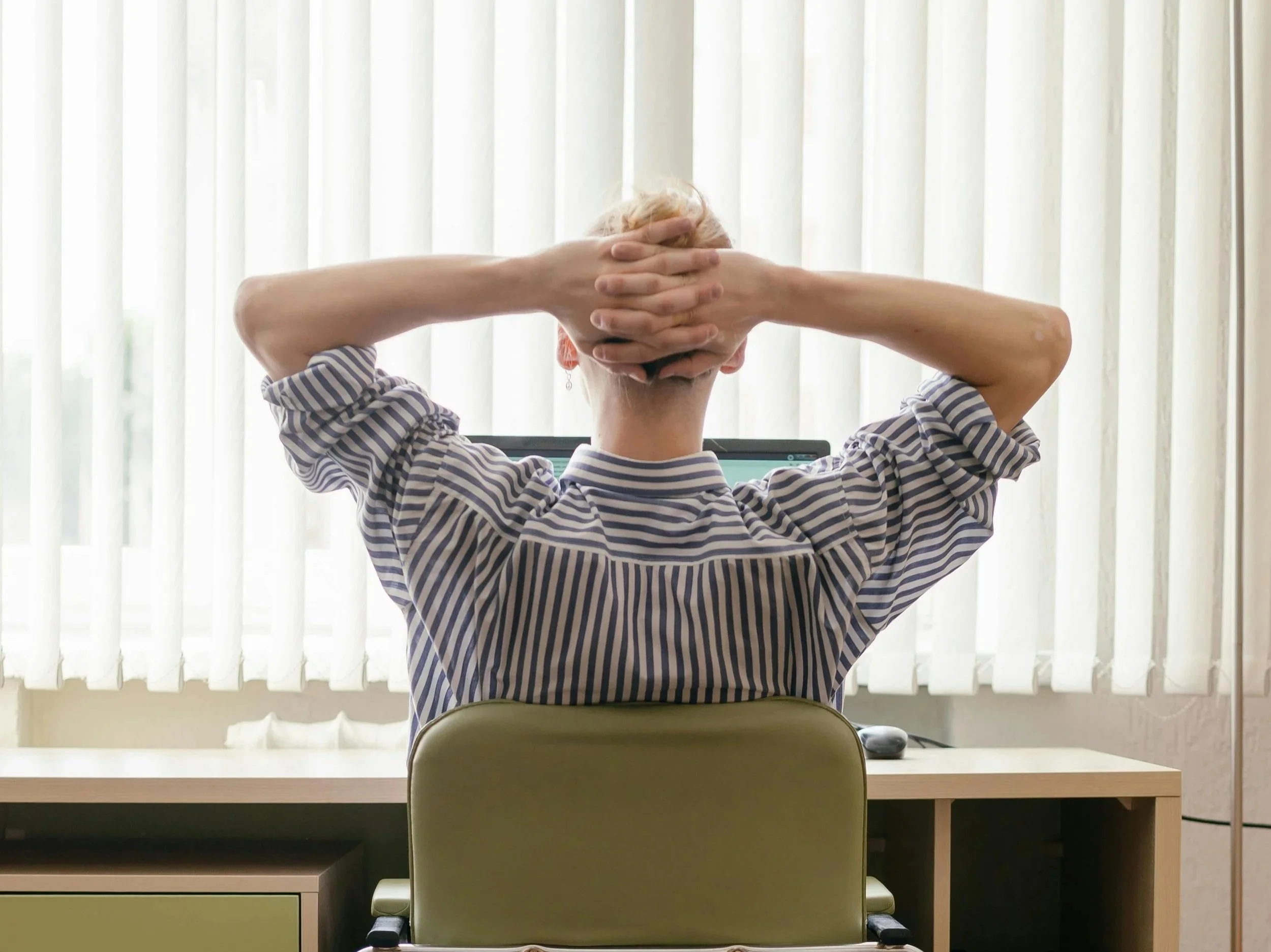 Person paused mid-task at a desk, representing ADHD-related difficulty with follow-through despite motivation.