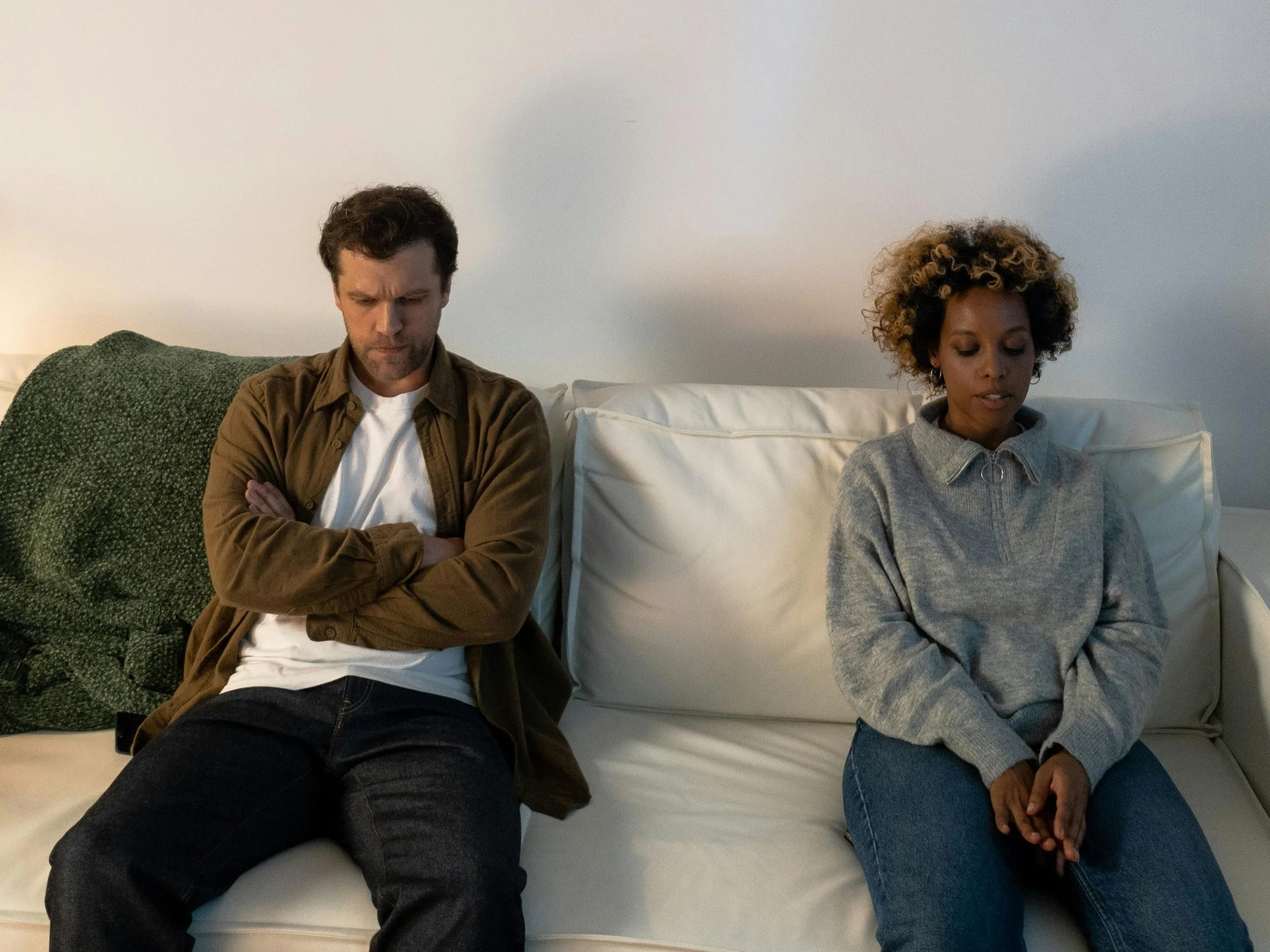 Couple sitting together in a quiet space after a difficult conversation, representing couples therapy beyond conflict.