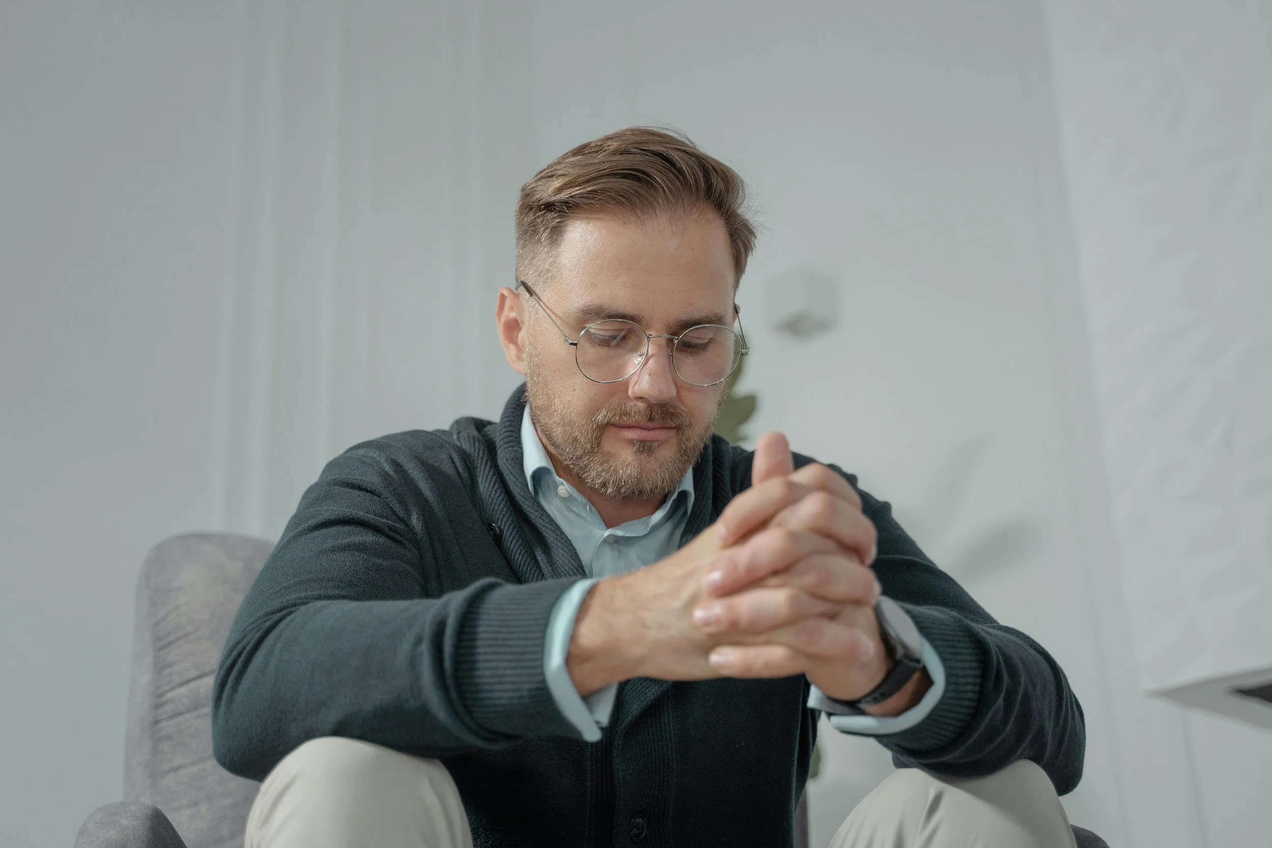 Person sitting calmly but appearing tense, reflecting internal anxiety despite outward composure