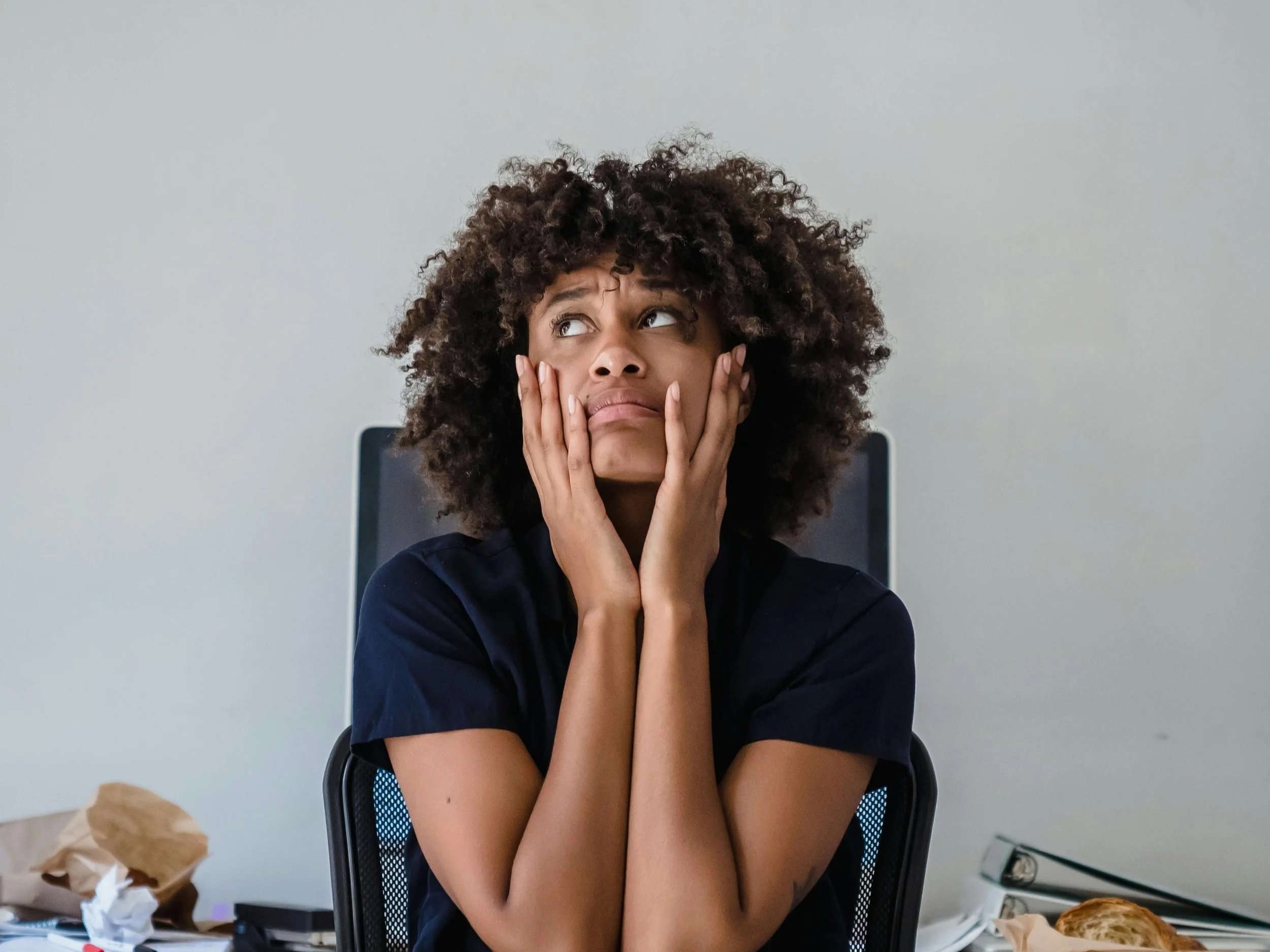 Person sitting with an overwhelmed expression, representing how burnout makes everyday tasks feel harder than they should.