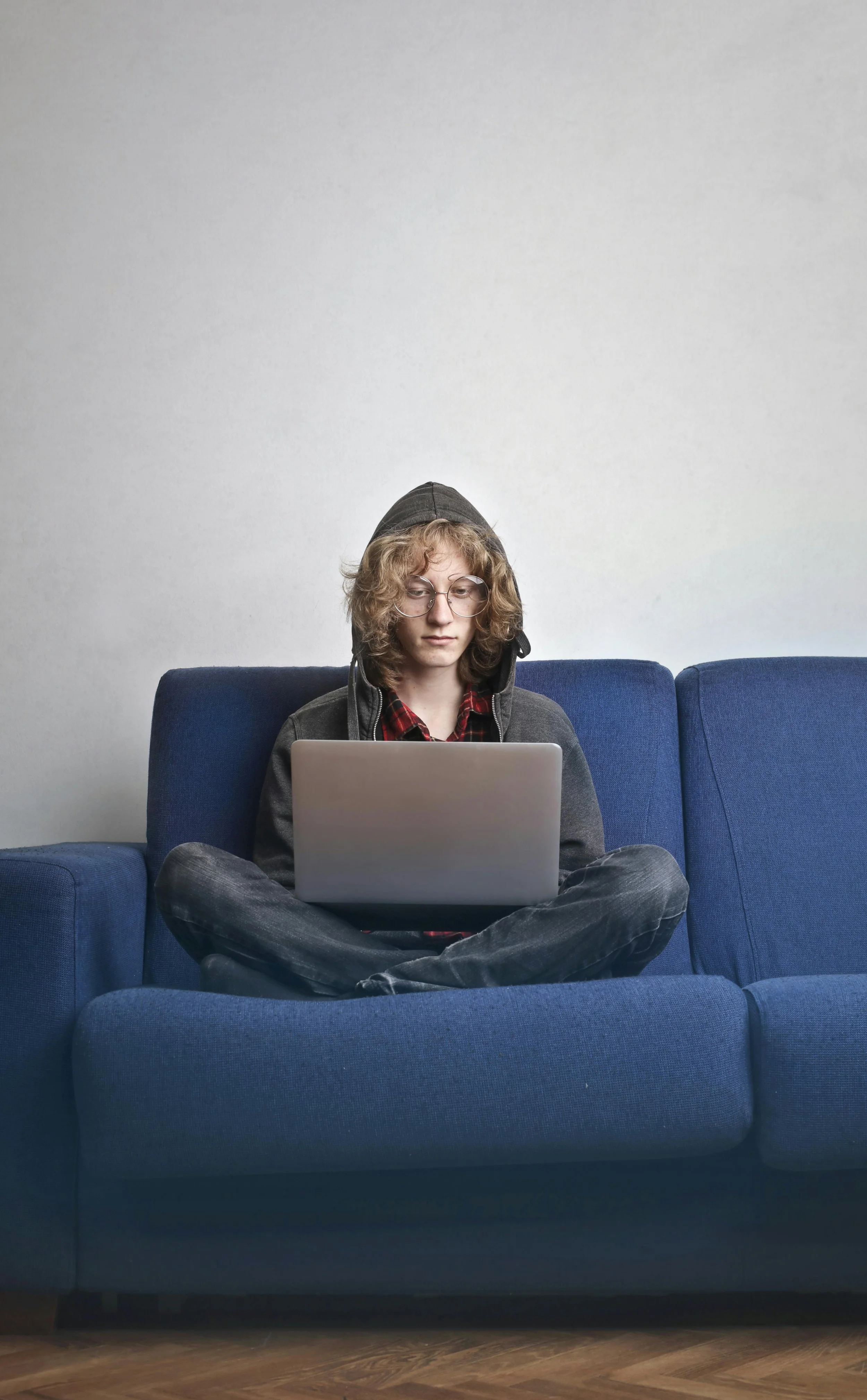 Adult sitting comfortably at home in soft natural light during an online therapy session, representing safe and accessible virtual trauma support