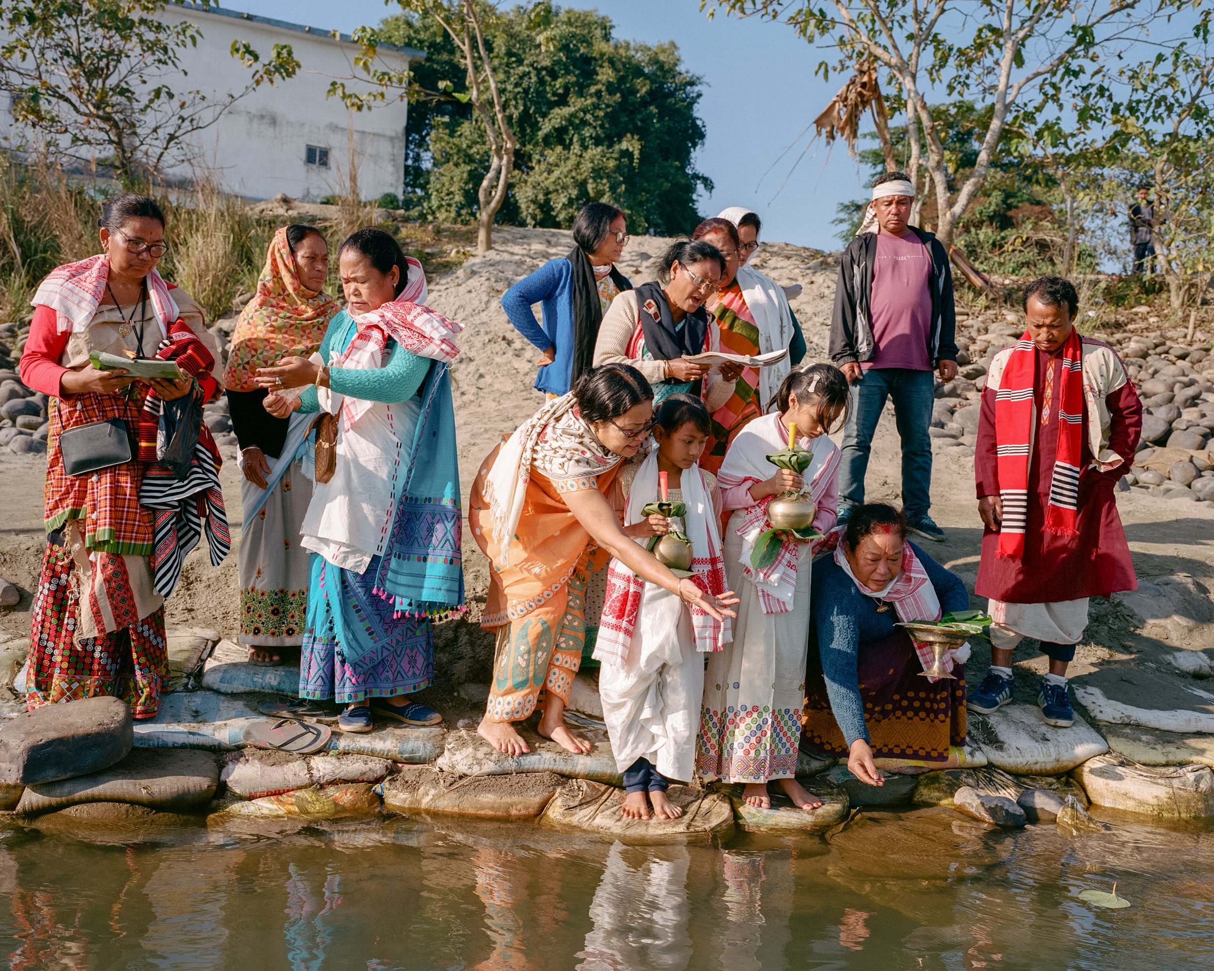   A Mising family holding a tribal ritual and collecting water from the river Kherkata which is a small offshoot of Brahmaputra. This narrow river flows west and south- west direction demarcating the northern boundary of Majuli. The holy water will b