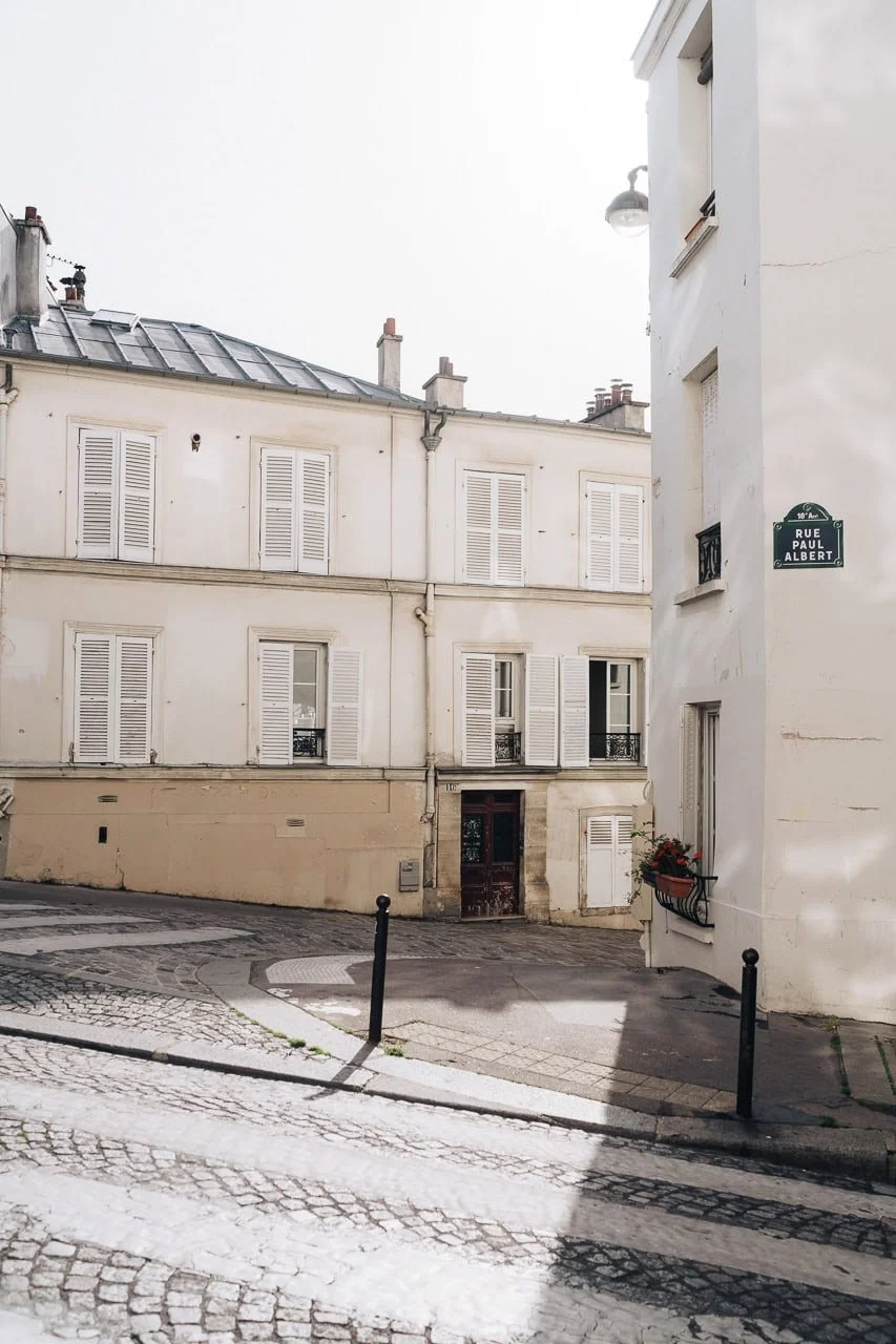 Quiet side street in Montmartre with warm sunrise light and classic Parisian architecture