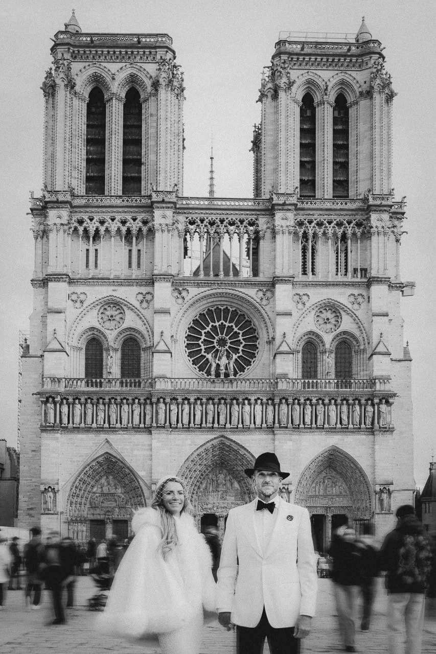 Couple standing together in front of Notre Dame in Paris following their destination wedding, photographed by Ian Holmes Photography