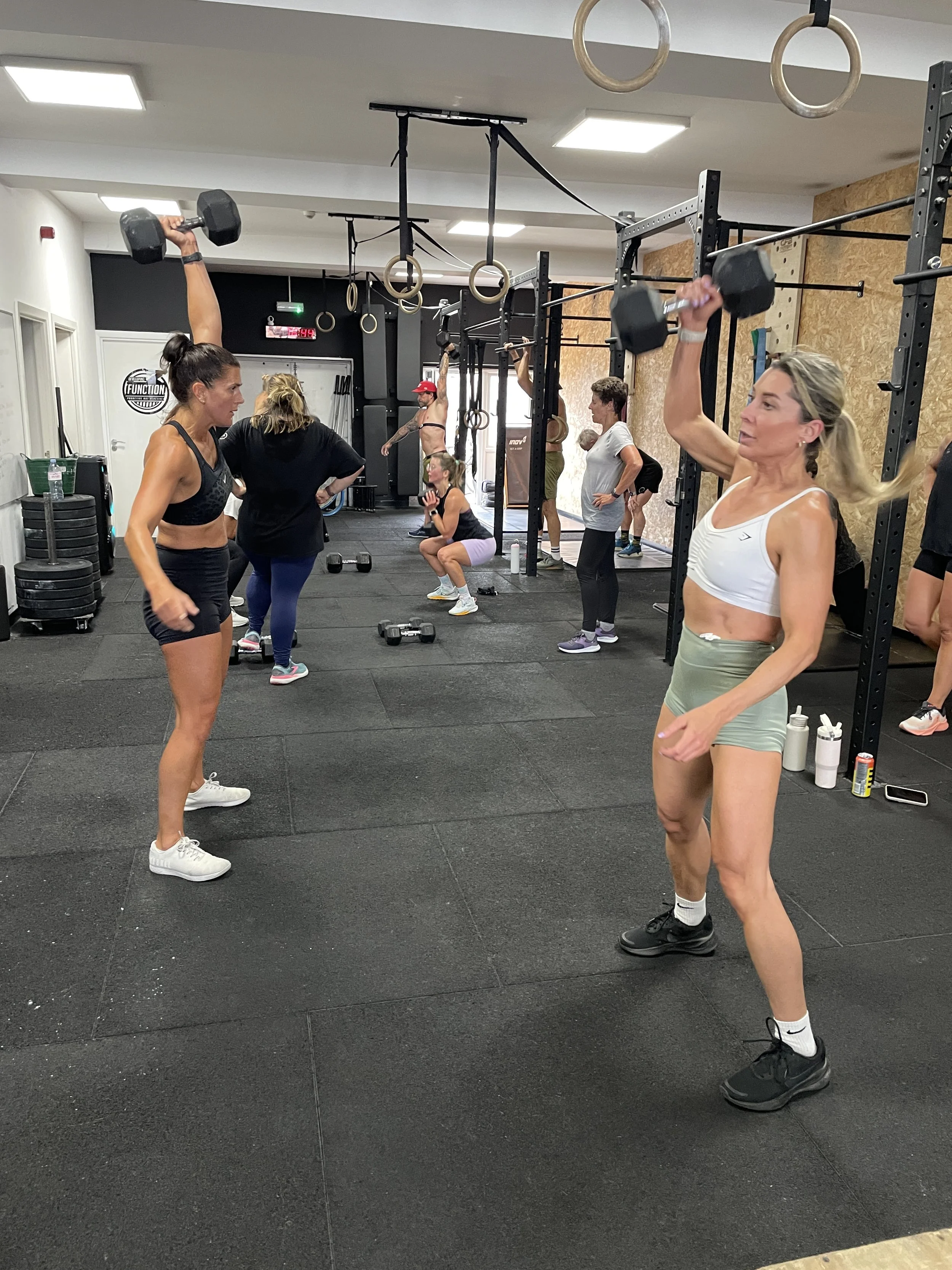 People working out in a gym, lifting weights and doing squats.