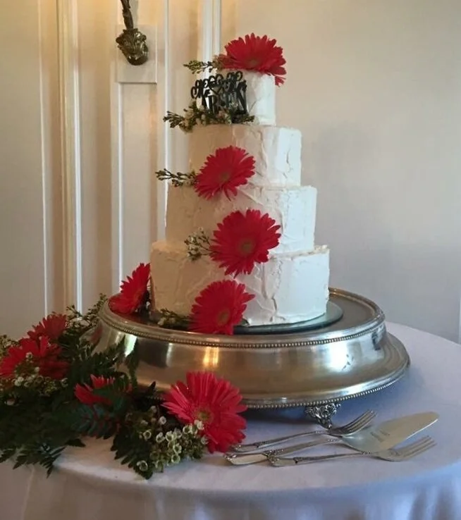 Rustic wedding cake with fresh gerbera daisies