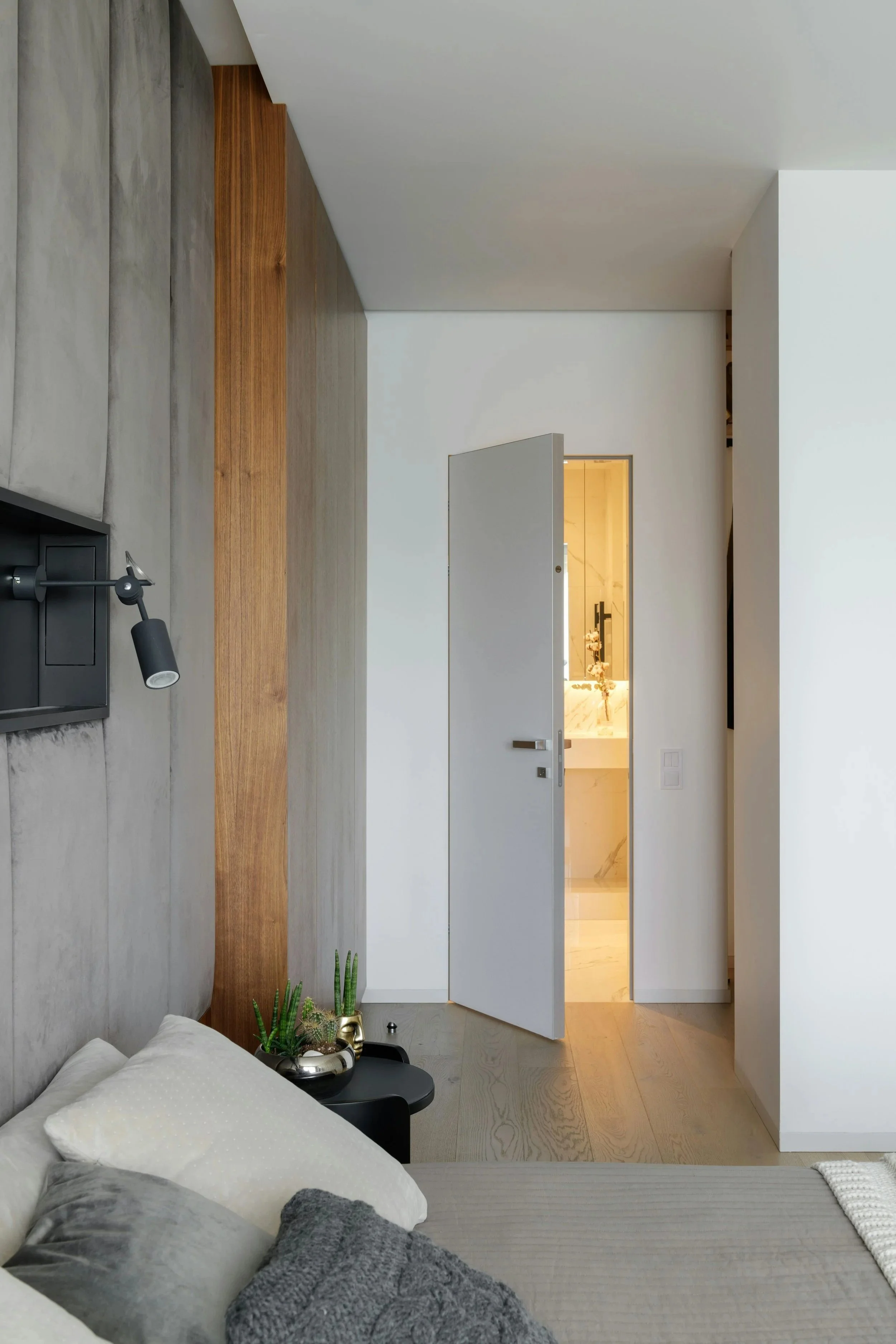 Bright, peaceful primary bedroom in a Calgary home renovation, featuring warm wood flooring, soft neutral finishes, and plenty of natural light.
