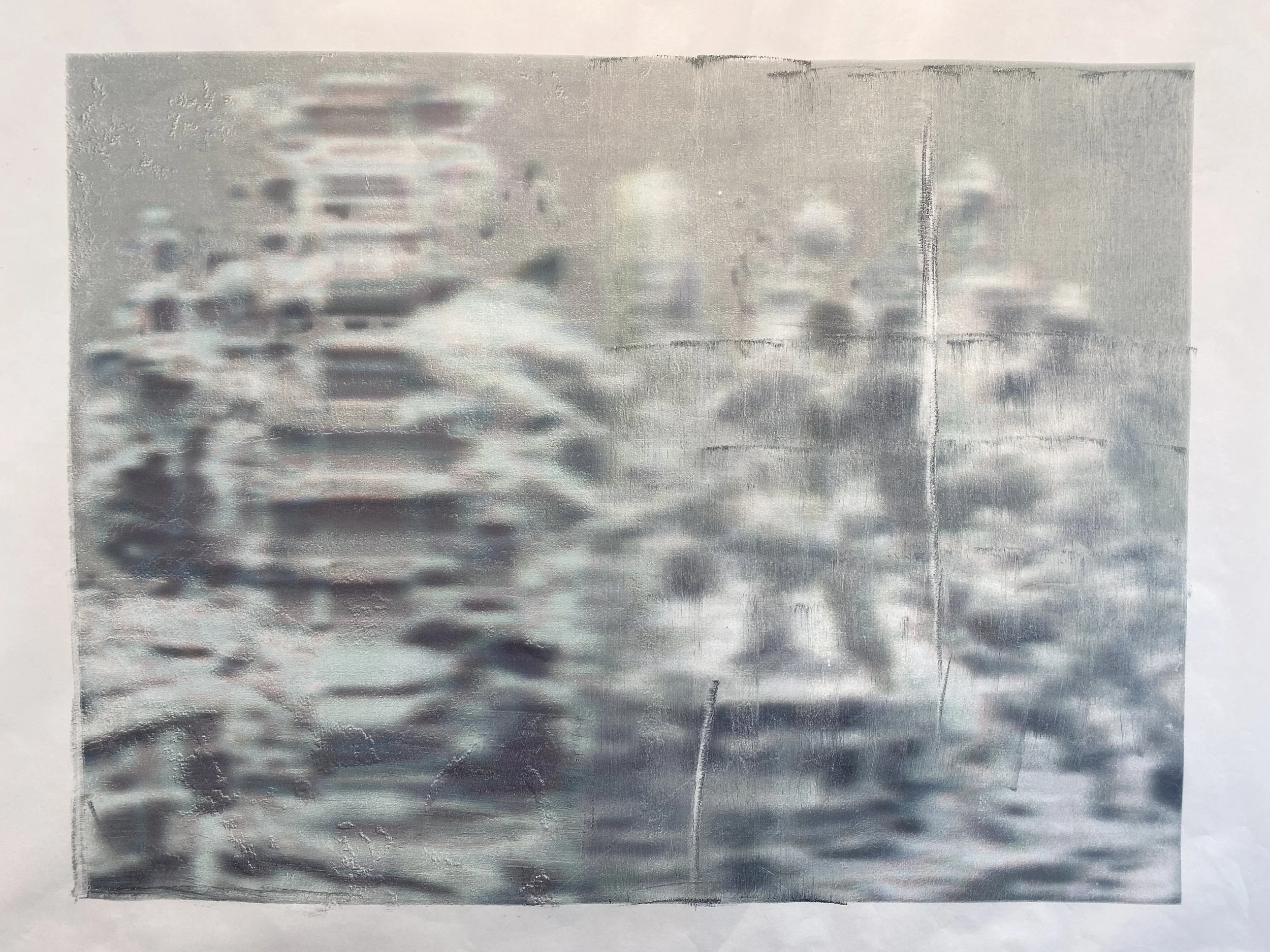 Blurry, abstract image with shades of grey, resembling rippling water or textured metal surface.