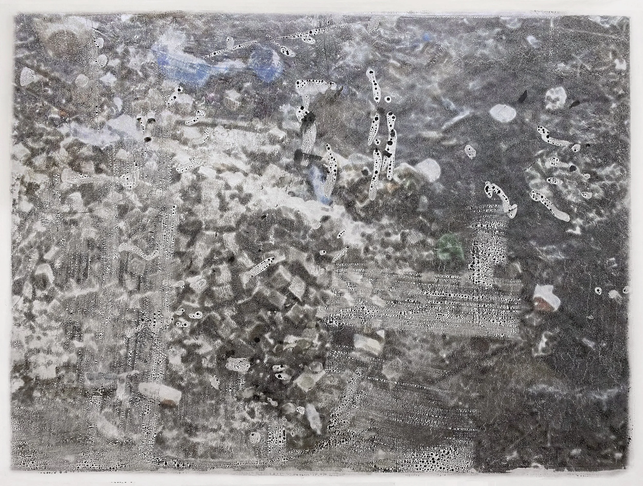 A soapy, wet glass surface with water bubbles and soap suds, obscuring the view of a gravel ground underneath.