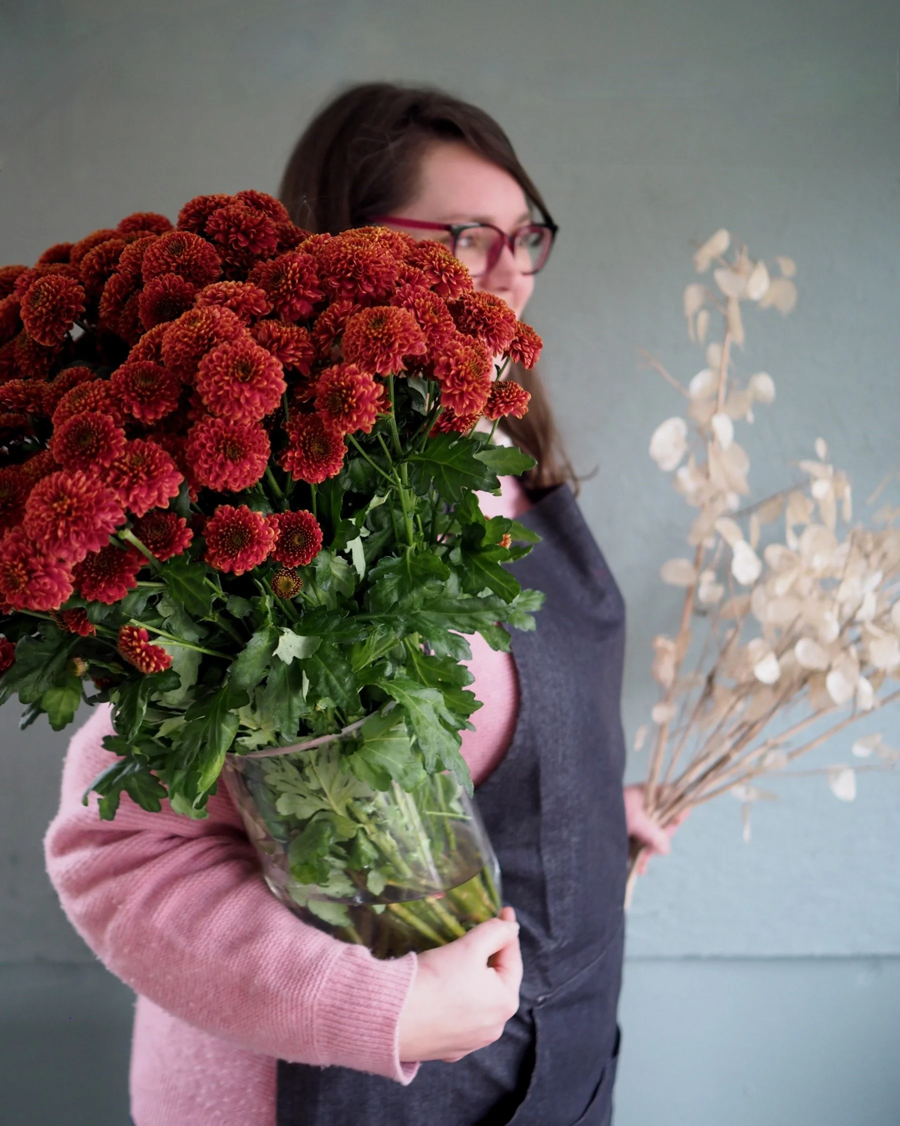 Freelancer florist Rachel holding large Christmas wreath she created