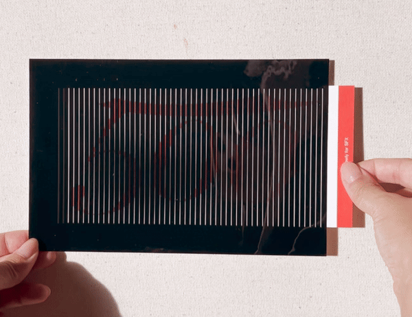 Person pulling a card out of its striped card sleeve creating an animating effect.