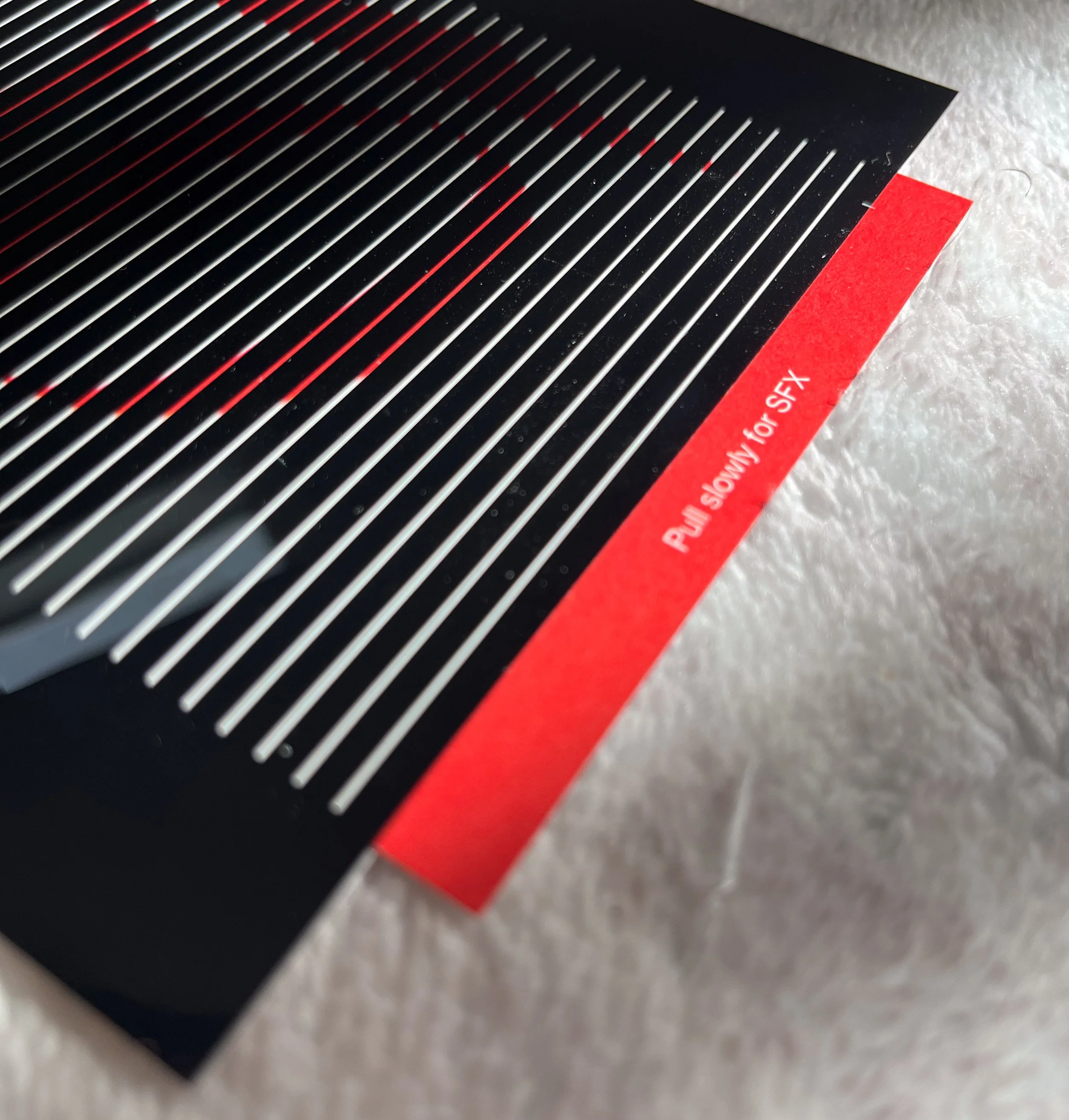Close-up of card with a red label that reads "Pull slowly for SFX."