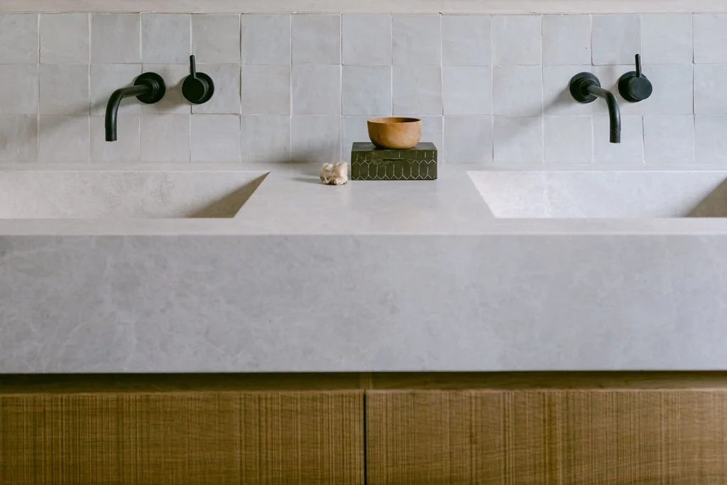 A stylish bathroom with two sinks set on white marble countertops, highlighting a sophisticated and clean aesthetic.