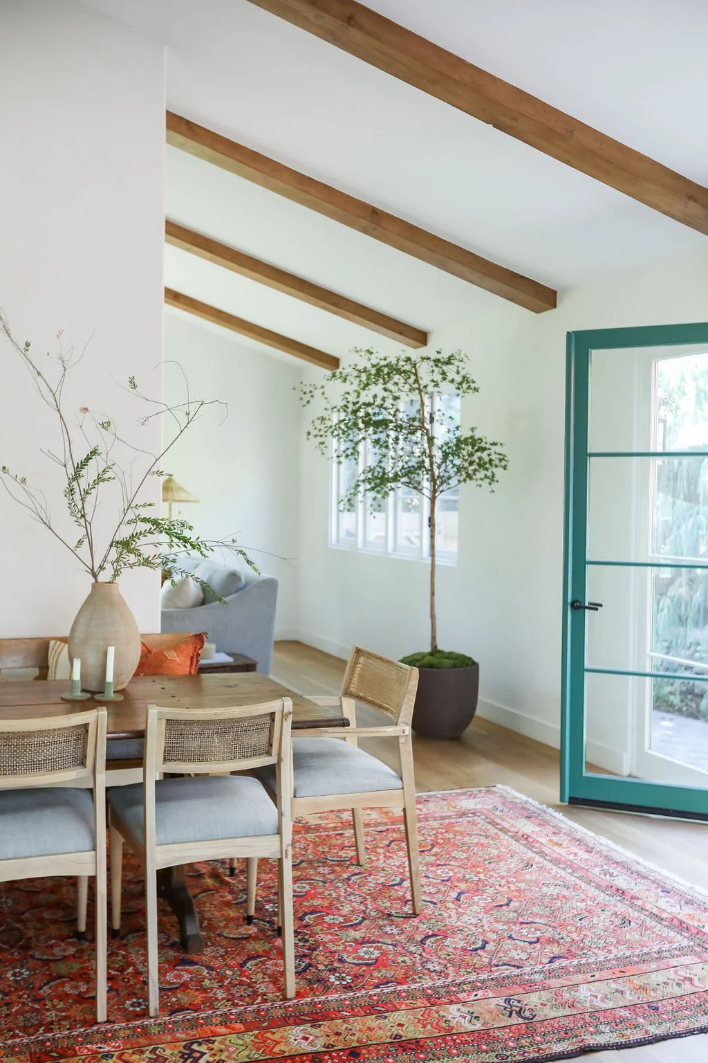 dining-room-with-vibrant-green-door-and-patterned-rug.jpg