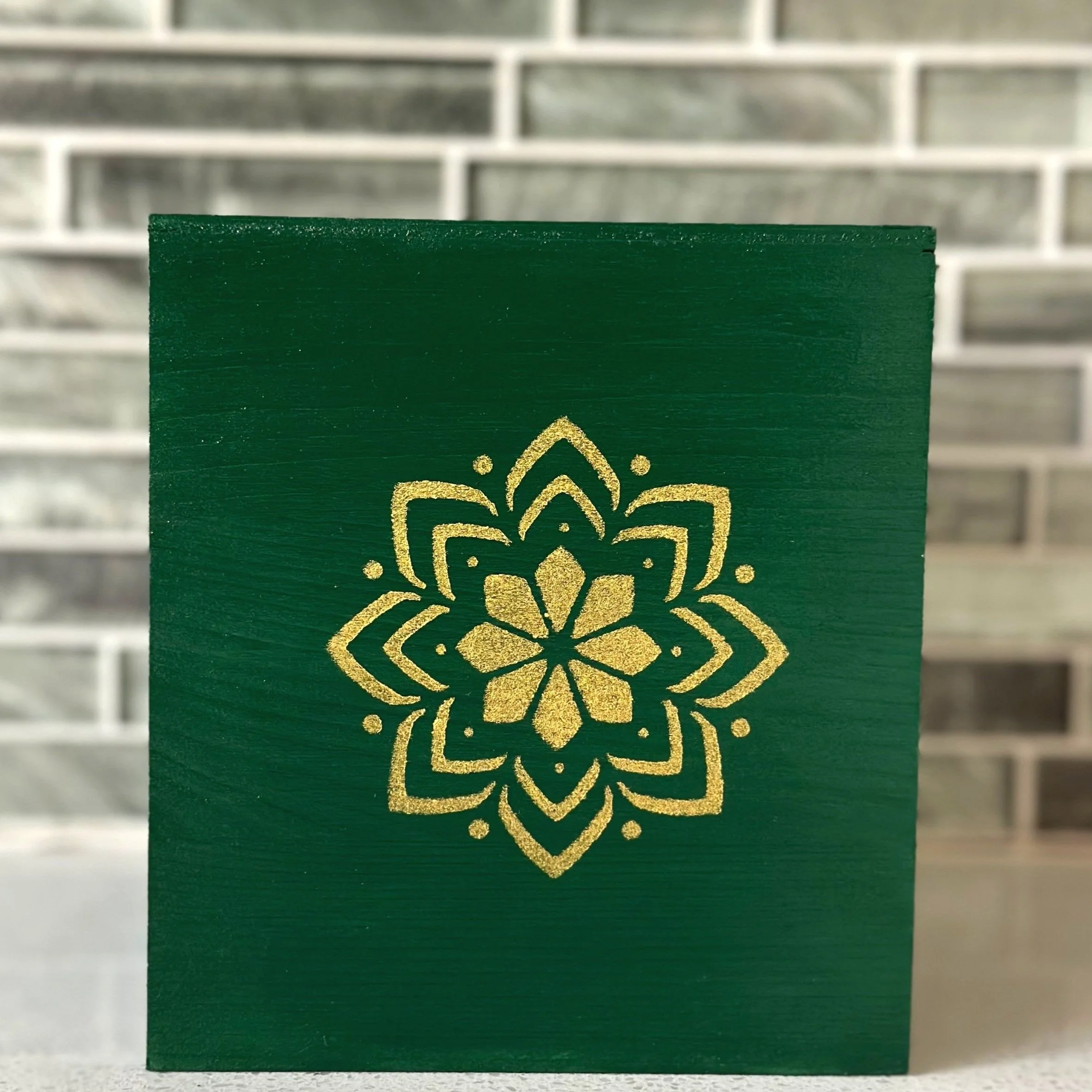 Green card with a gold decorative design in the center