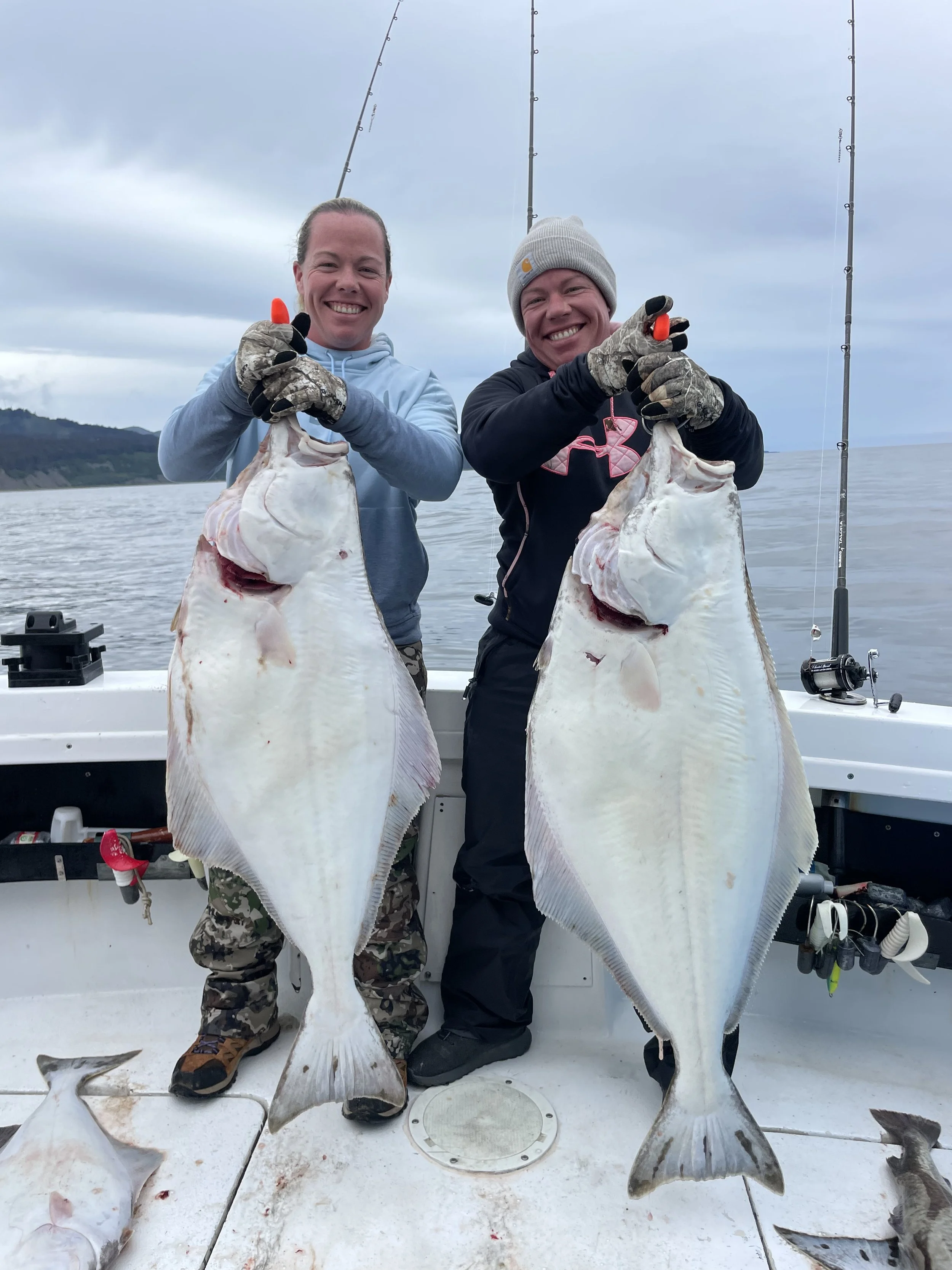 Two Women holding halibut from Homer Alaska