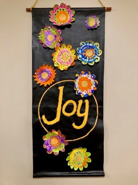 This banner project was so much fun. The cut out flowers were painted by the adults with special needs and then layered and adhered to the banner which hung outside their rooms.