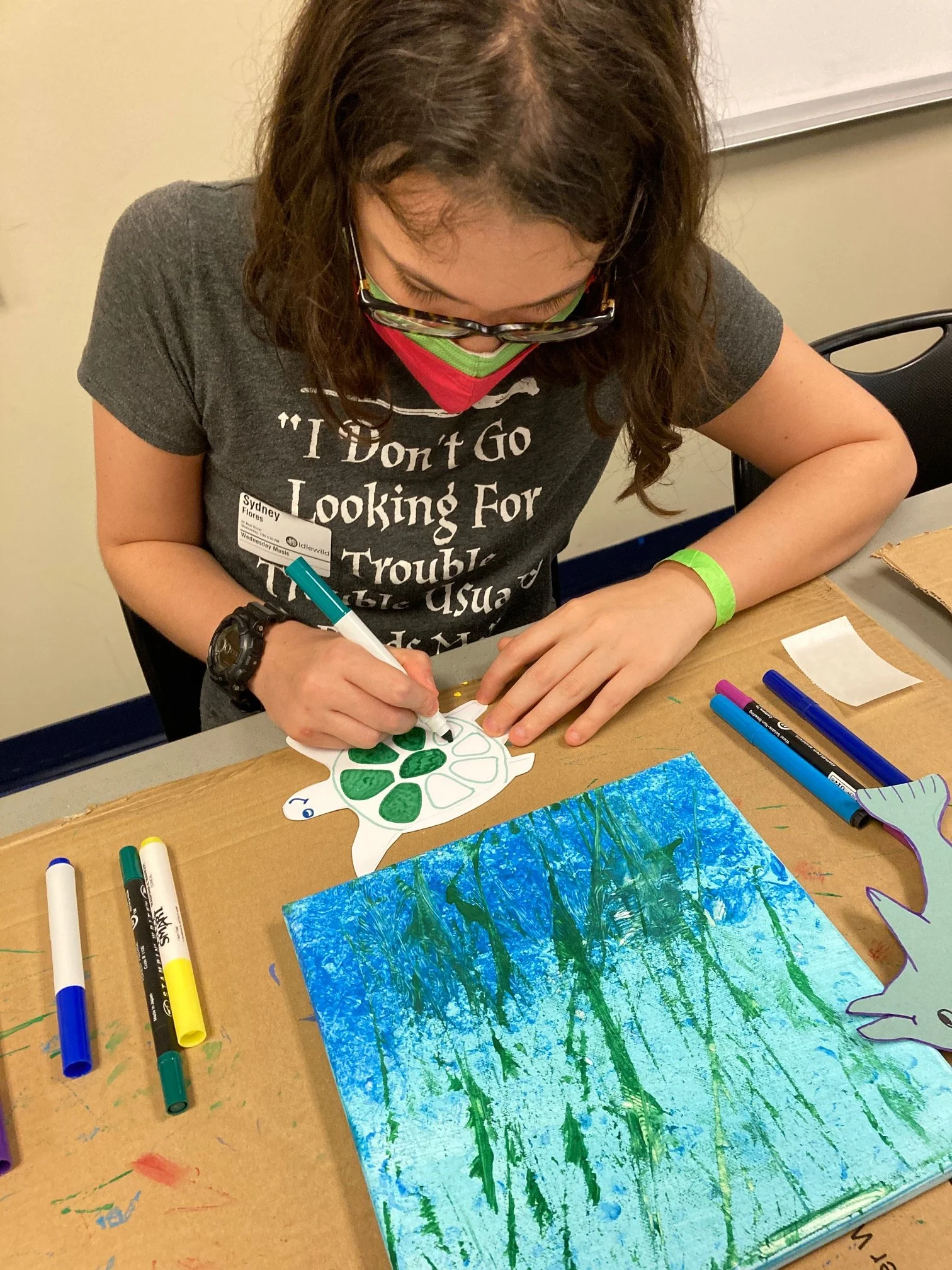 Adult with special needs creating her sea creature for her painting.