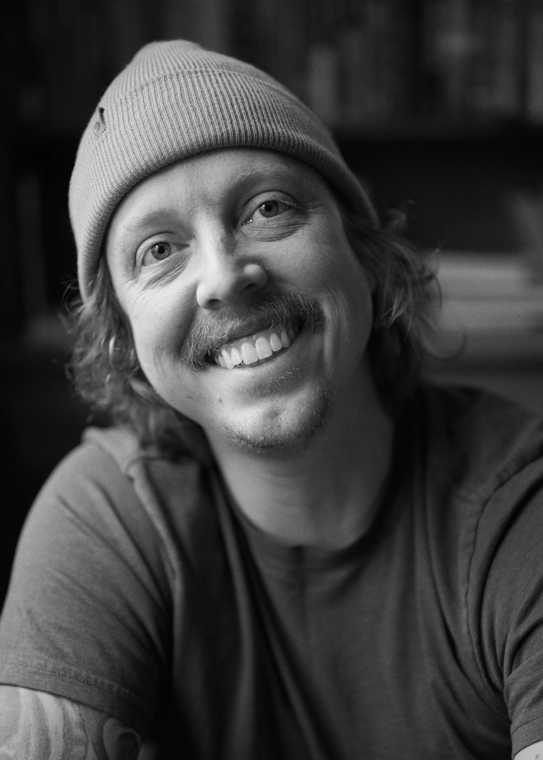 Blake Robertshaw portrait with long curly hair, mustache, and beanie.