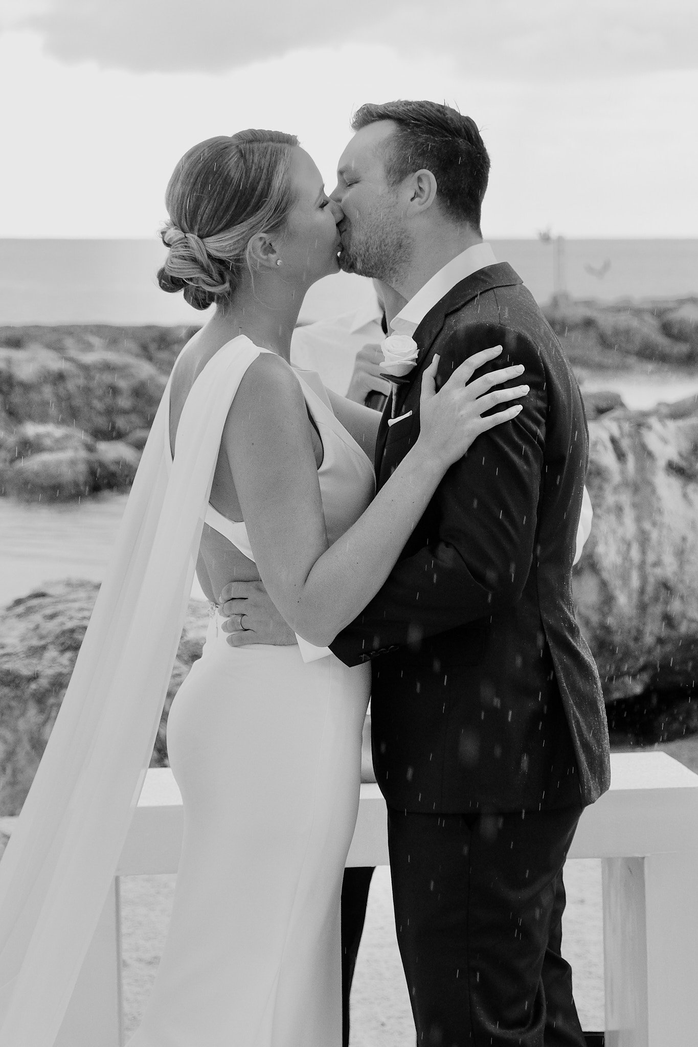 A couple shares their first kiss on a beach in Mexico at the Hard Rock Riviera Maya.