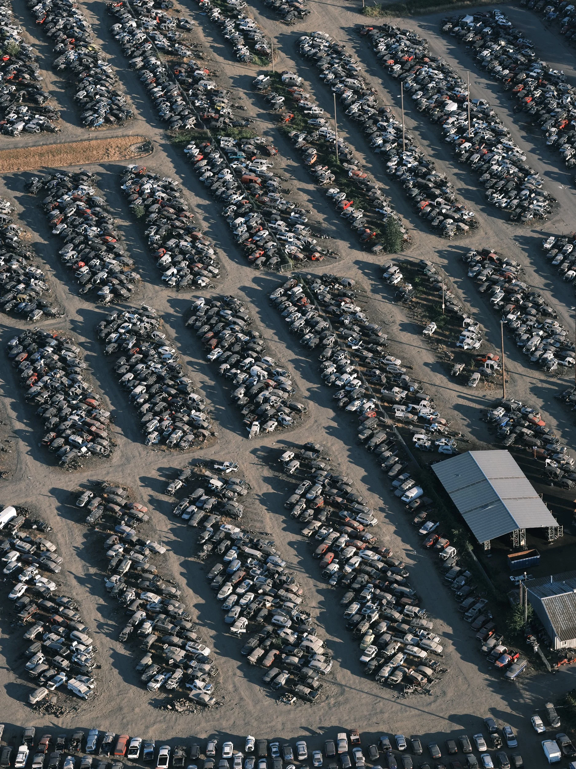 An aerial view of a junkyard filled with rows and rows of cars made easy to view from this perspective in Eugene, Oregon.