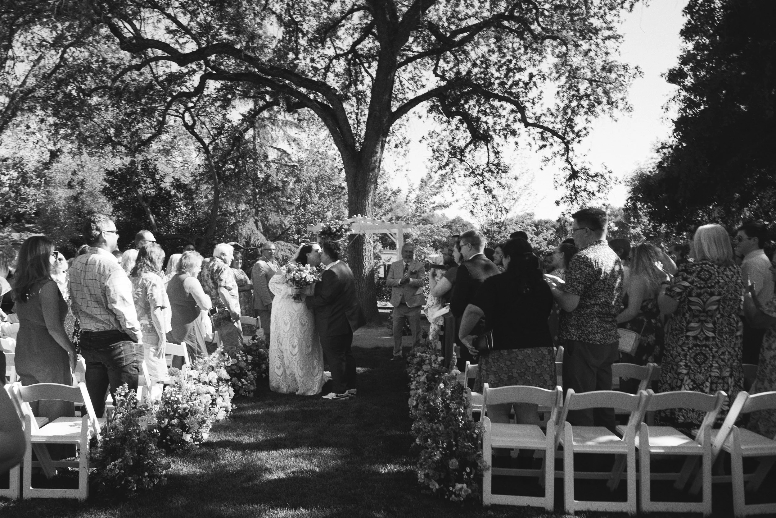 A LGBTQ+ couple walks down the aisle at the Flower Farm Inn, in Loomis California creating the perfect imperfect photograph.
