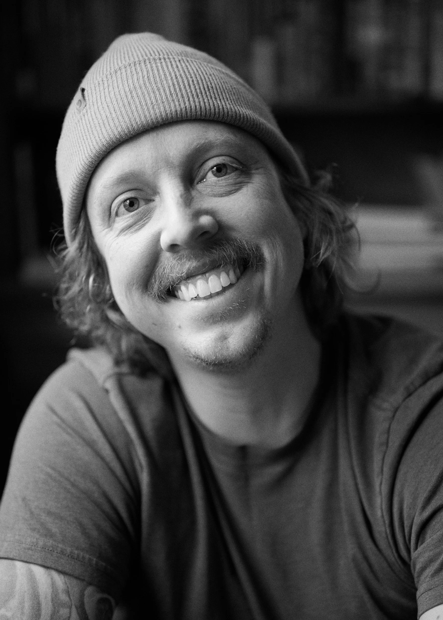 Blake Robertshaw portrait with long curly hair, mustache, and beanie.