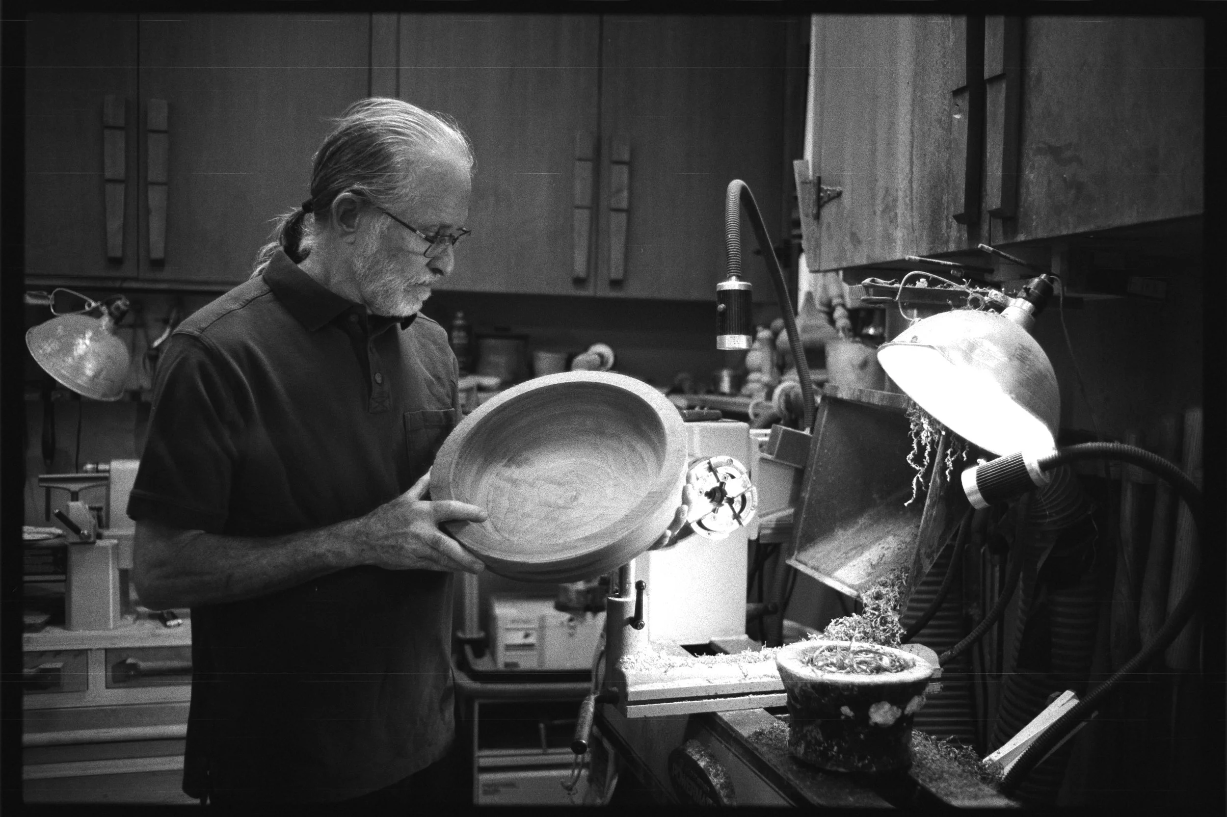 Film photo of carpenter Gary Katz turning a wooden bowl in his Oregon woodshop.