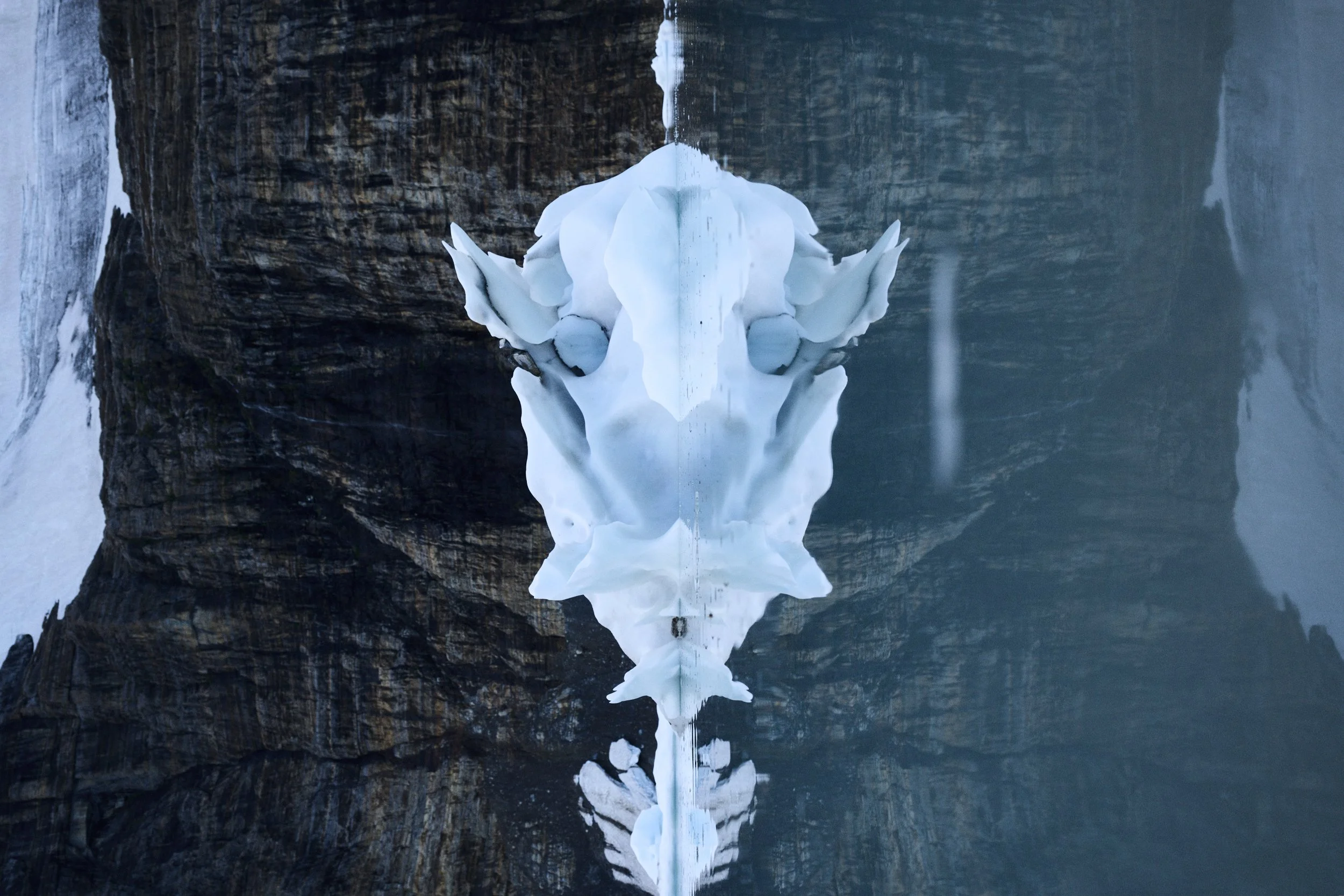 An iceberg floats in a lake from Grinnell Glacier, the glacier rotated sidewise looks like the head of a buffalo or mountain goat.
