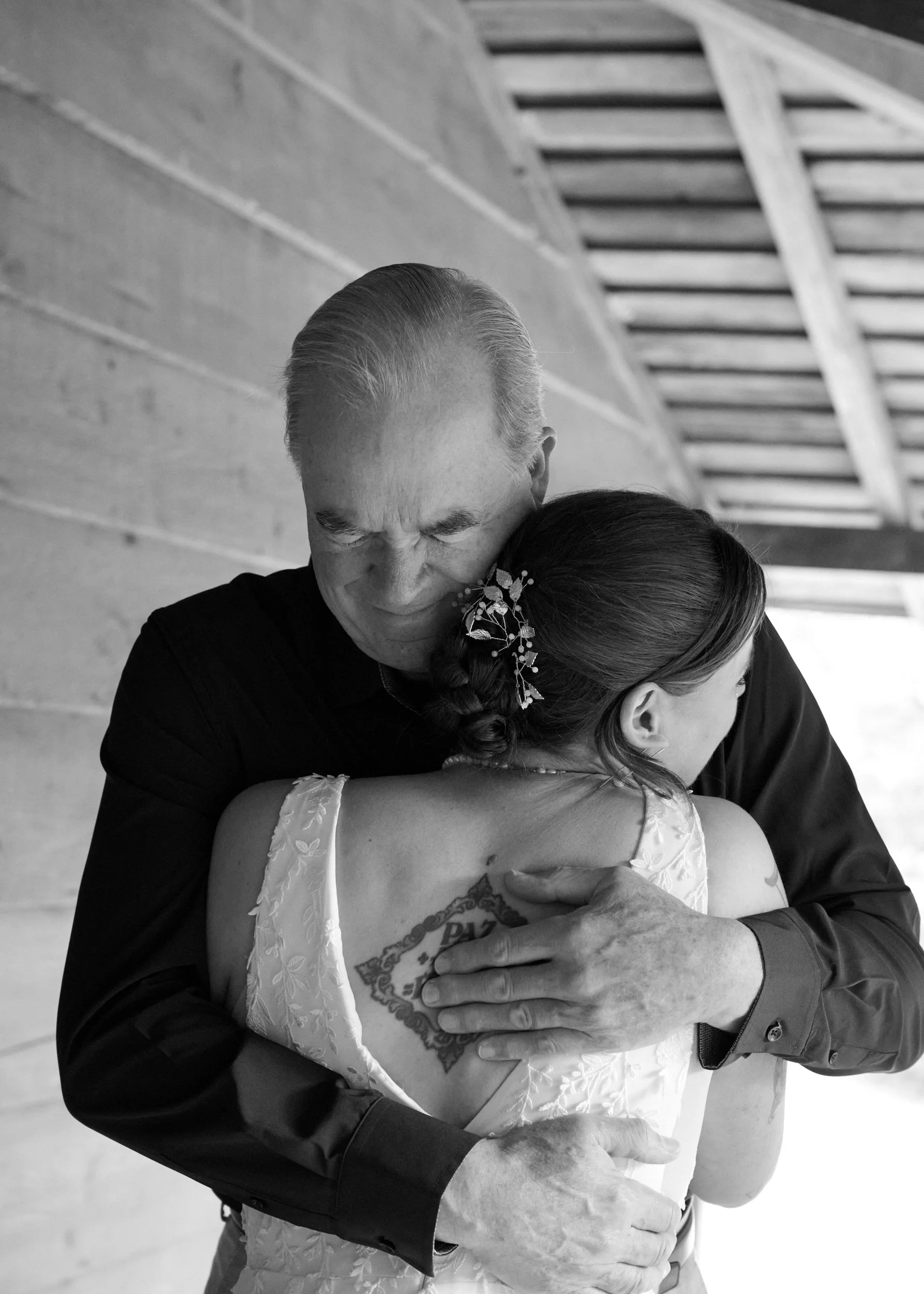 A teary eyed father hugs his daughter in her wedding dress during a first look near Portland, Oregon.