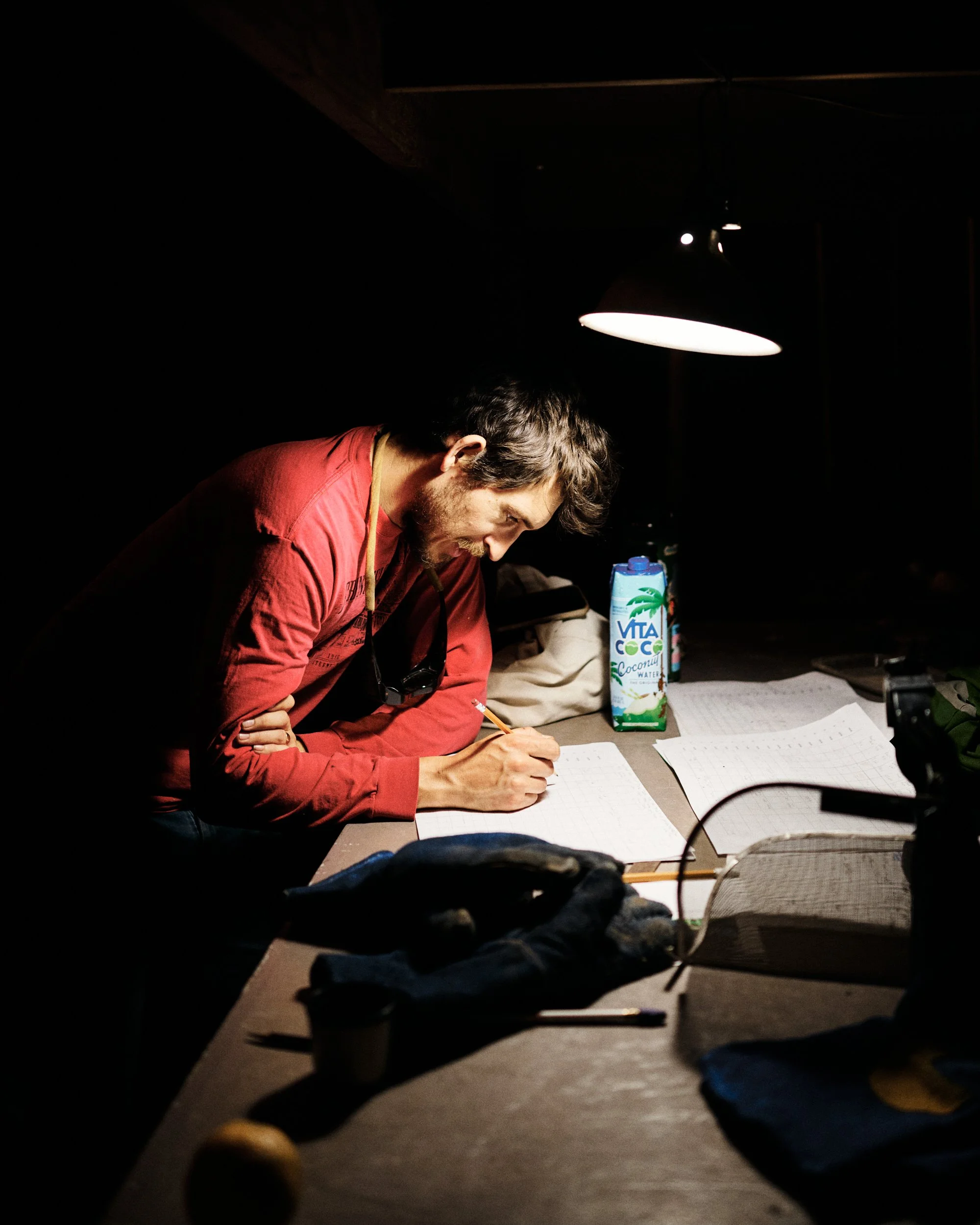 Potter Hamish Jackson wearing a red shirt works at a kiln late into the night at an Oregon pottery studio.