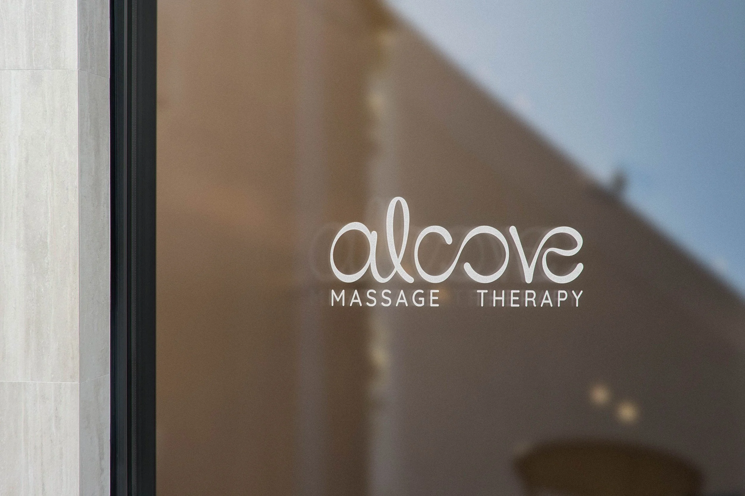 Glass door sign for 'Alcove Massage Therapy'